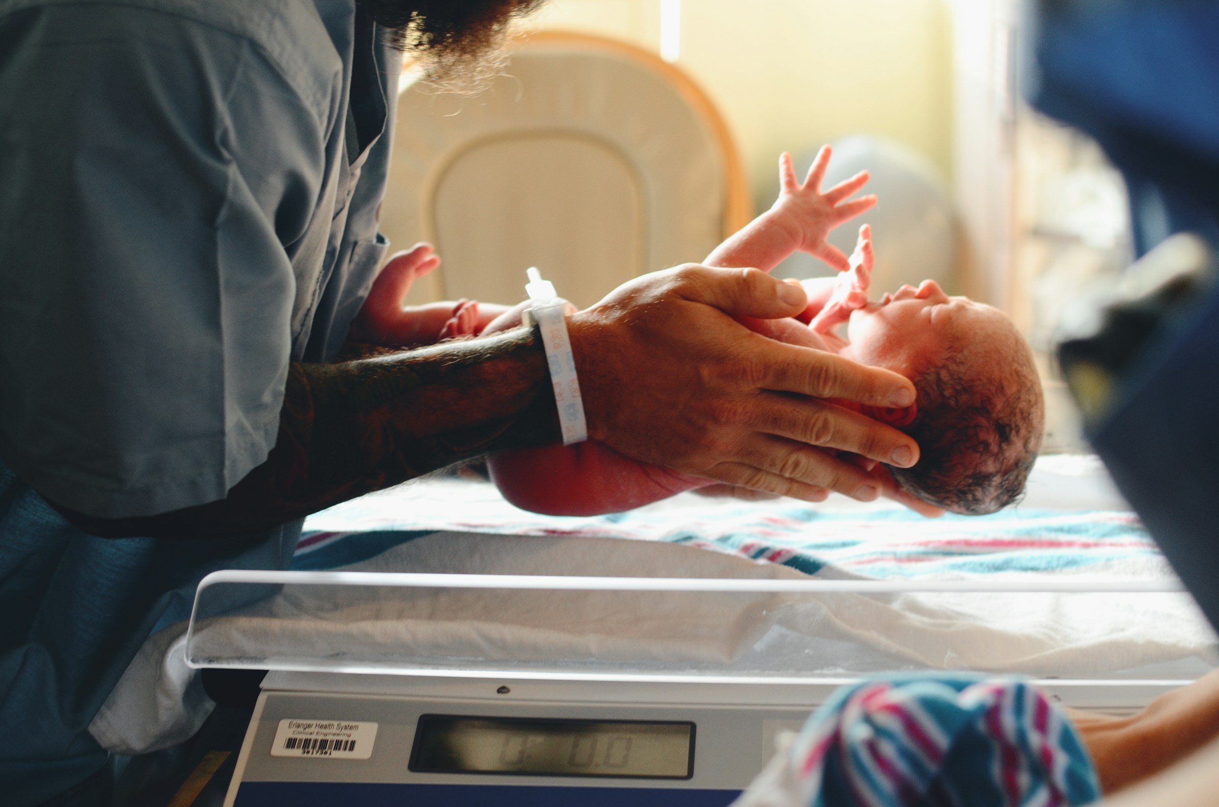 Un médico poniendo a un recién nacido en una báscula | Fuente: Unsplash
