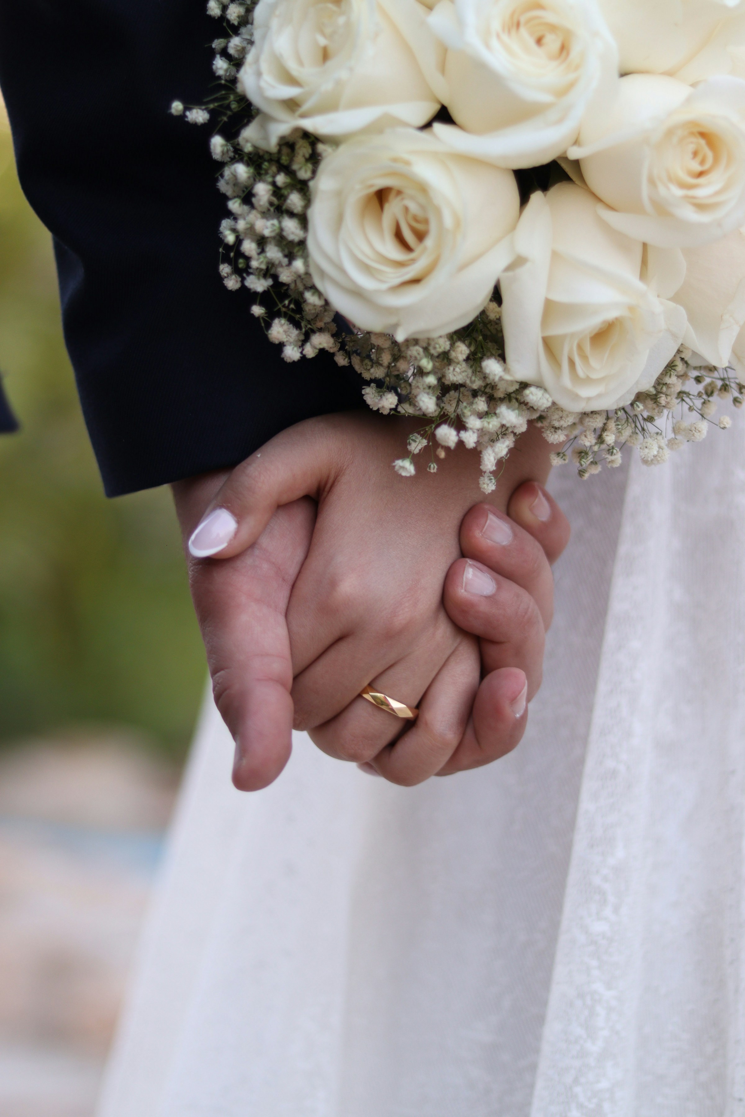 Primer plano de unos novios cogidos de la mano | Fuente: Unsplash