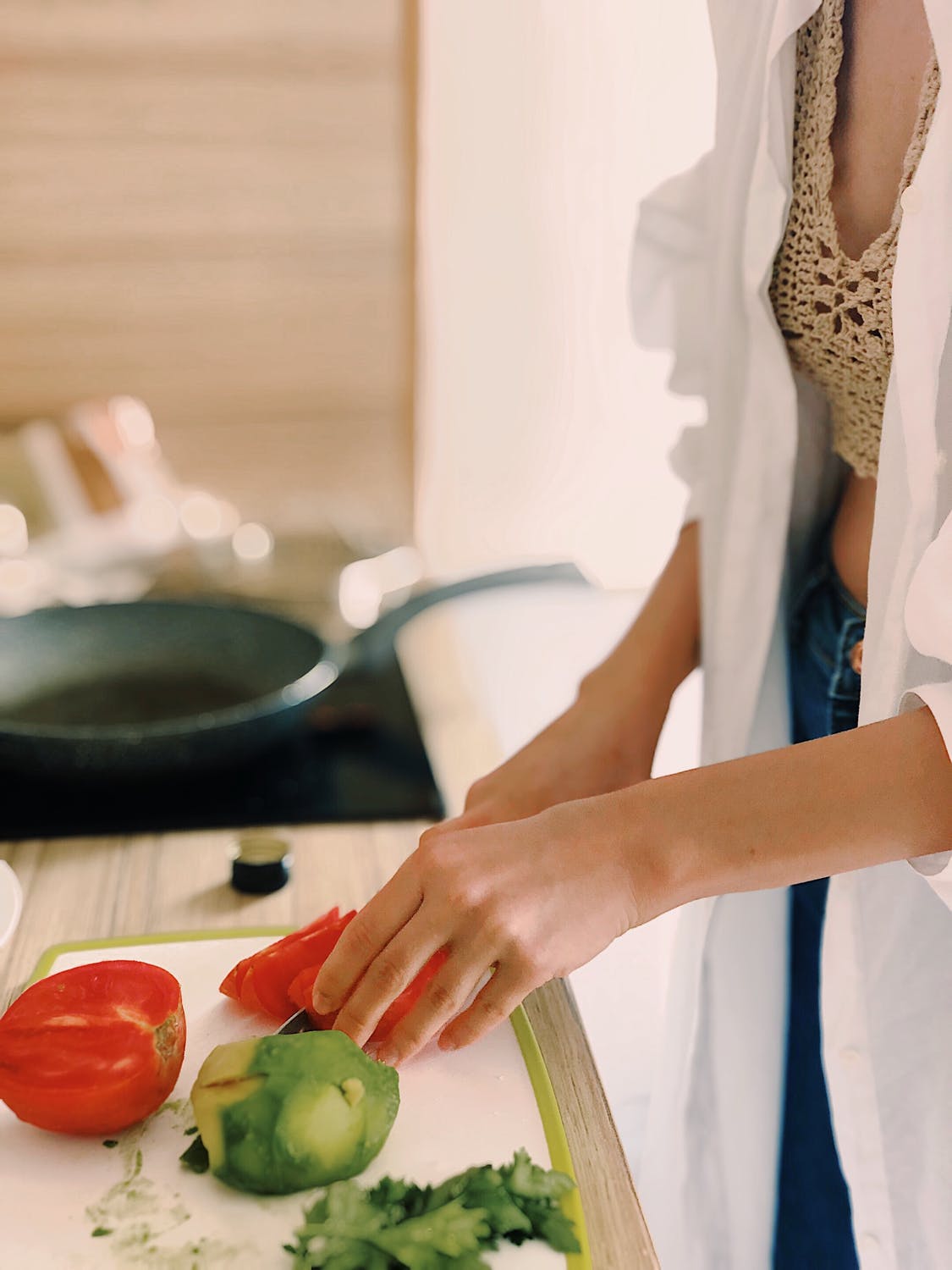 Mujer cortando los vegetales sobre una tabla mientras cocina. | Imagen: Pexels