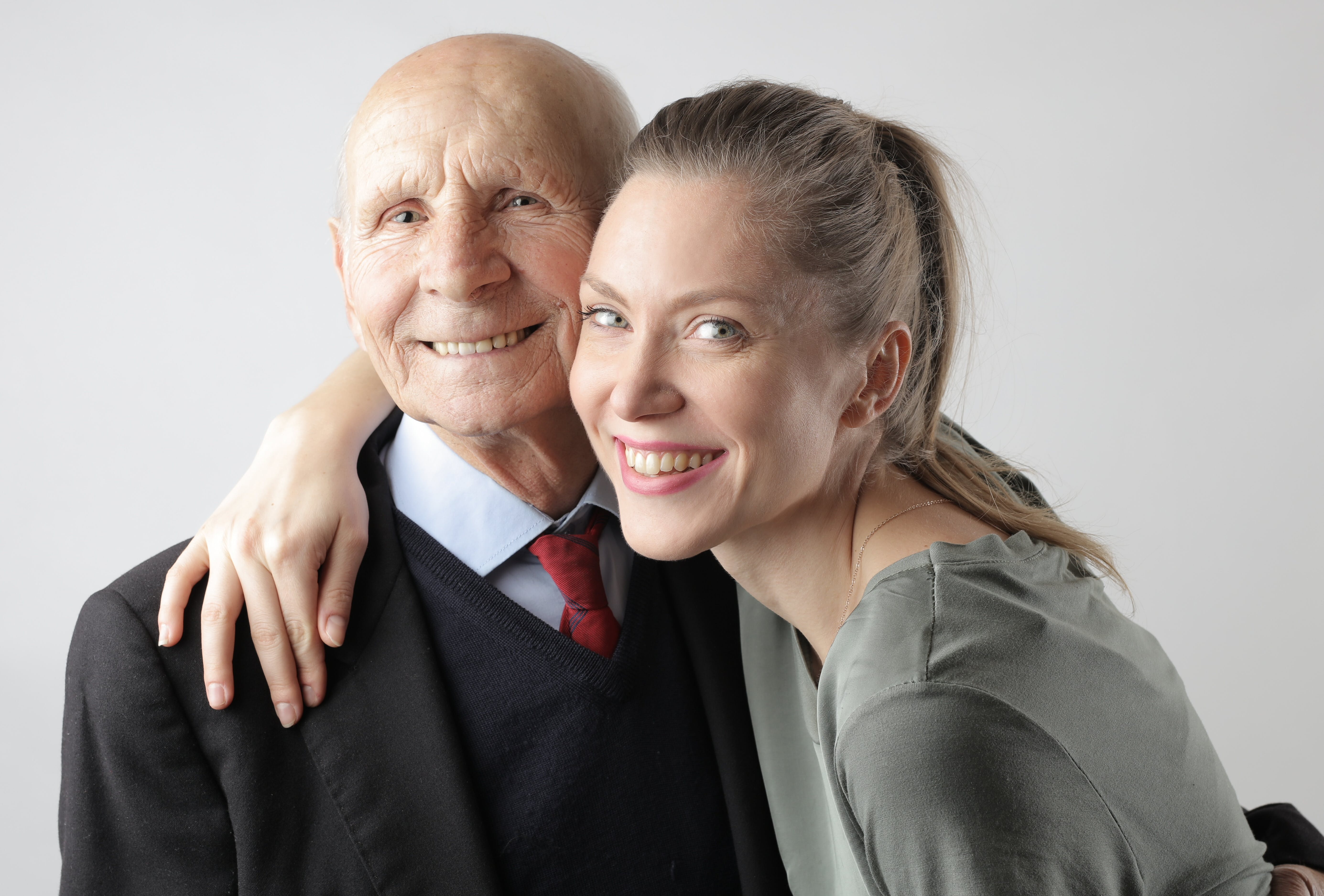 Un anciano y una joven posando para un retrato | Foto: Pexels