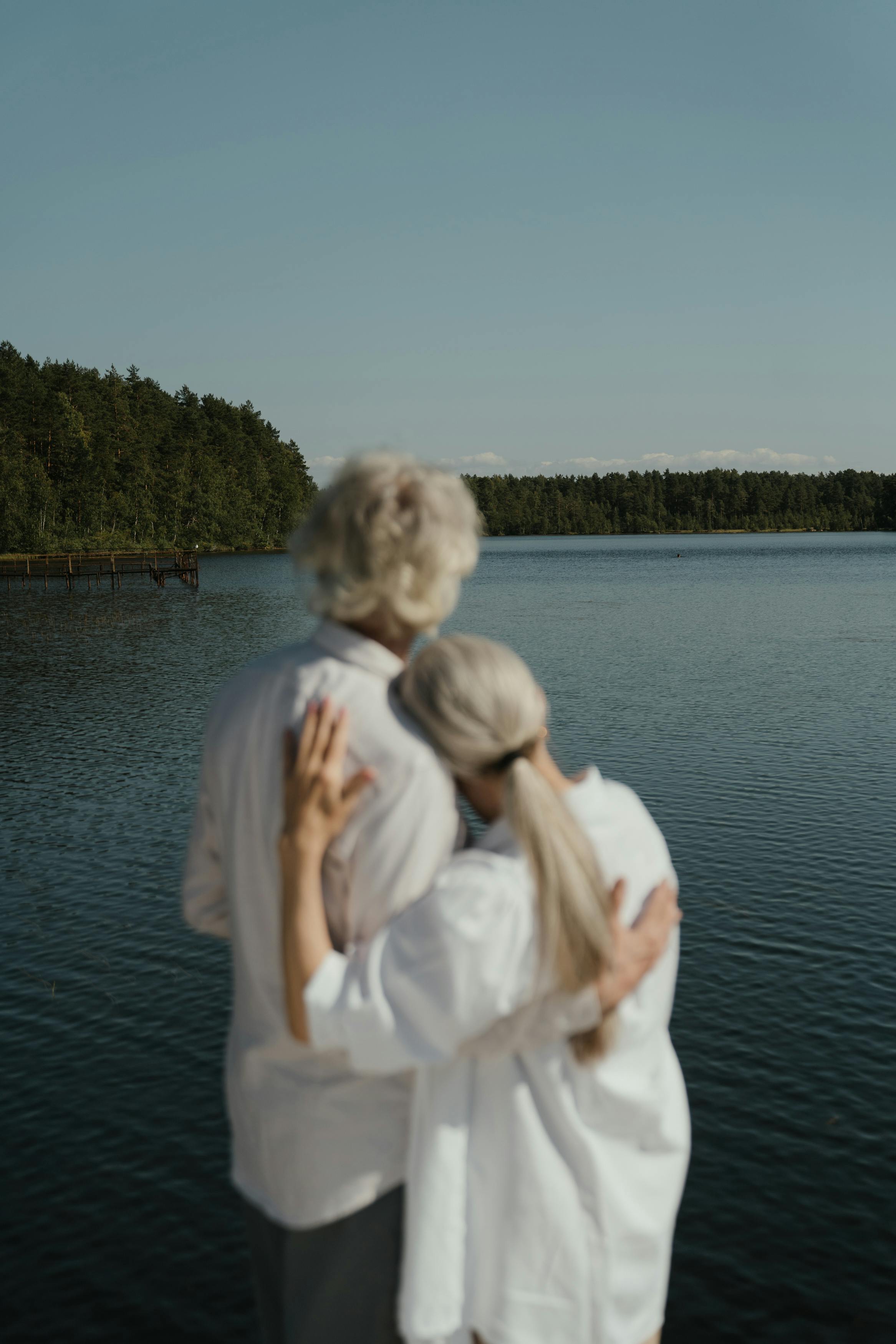 Pareja abrazándose frente a un lago | Foto: Pexels
