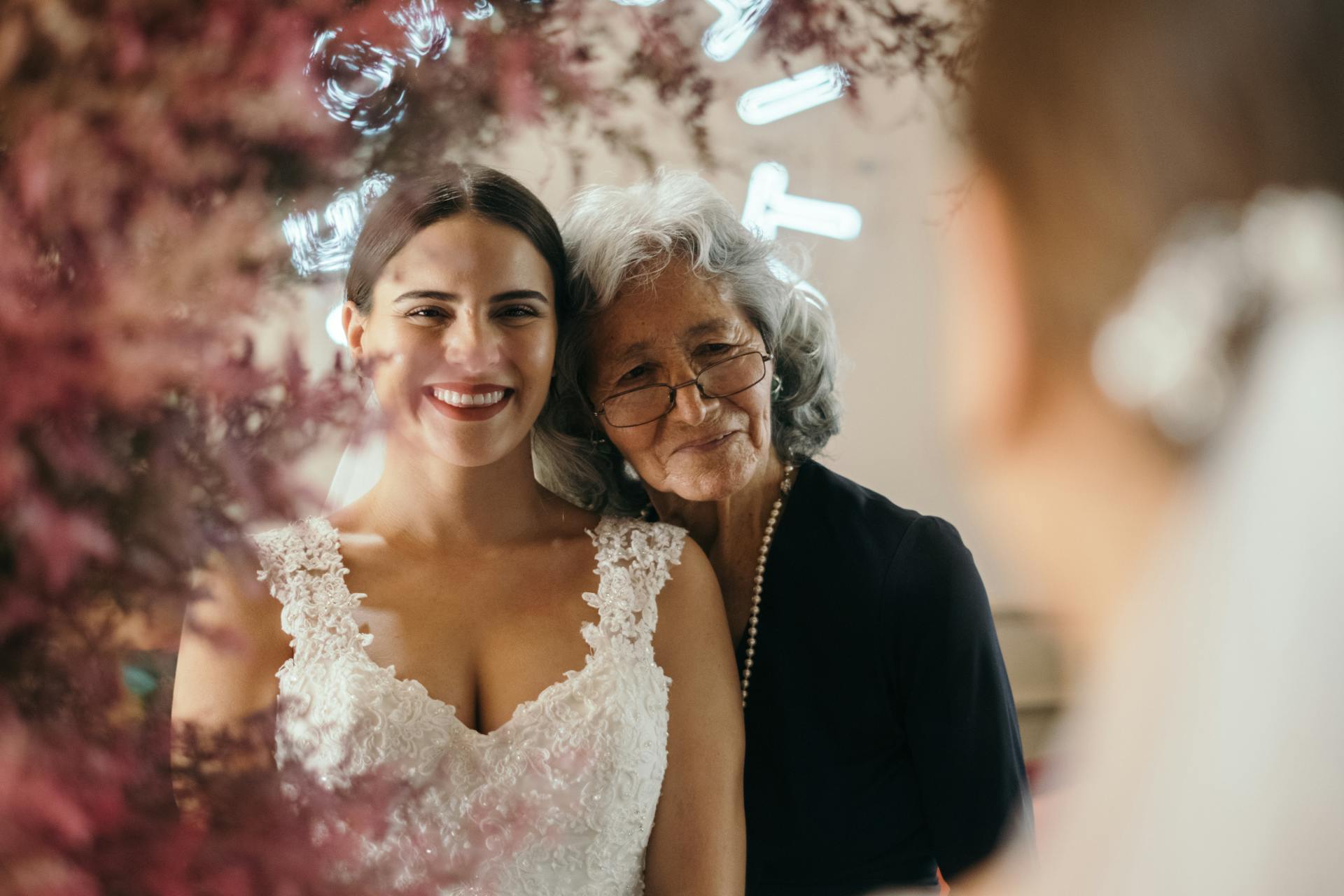 Una novia y su abuela mirándose en un espejo y sonriendo | Fuente: Pexels
