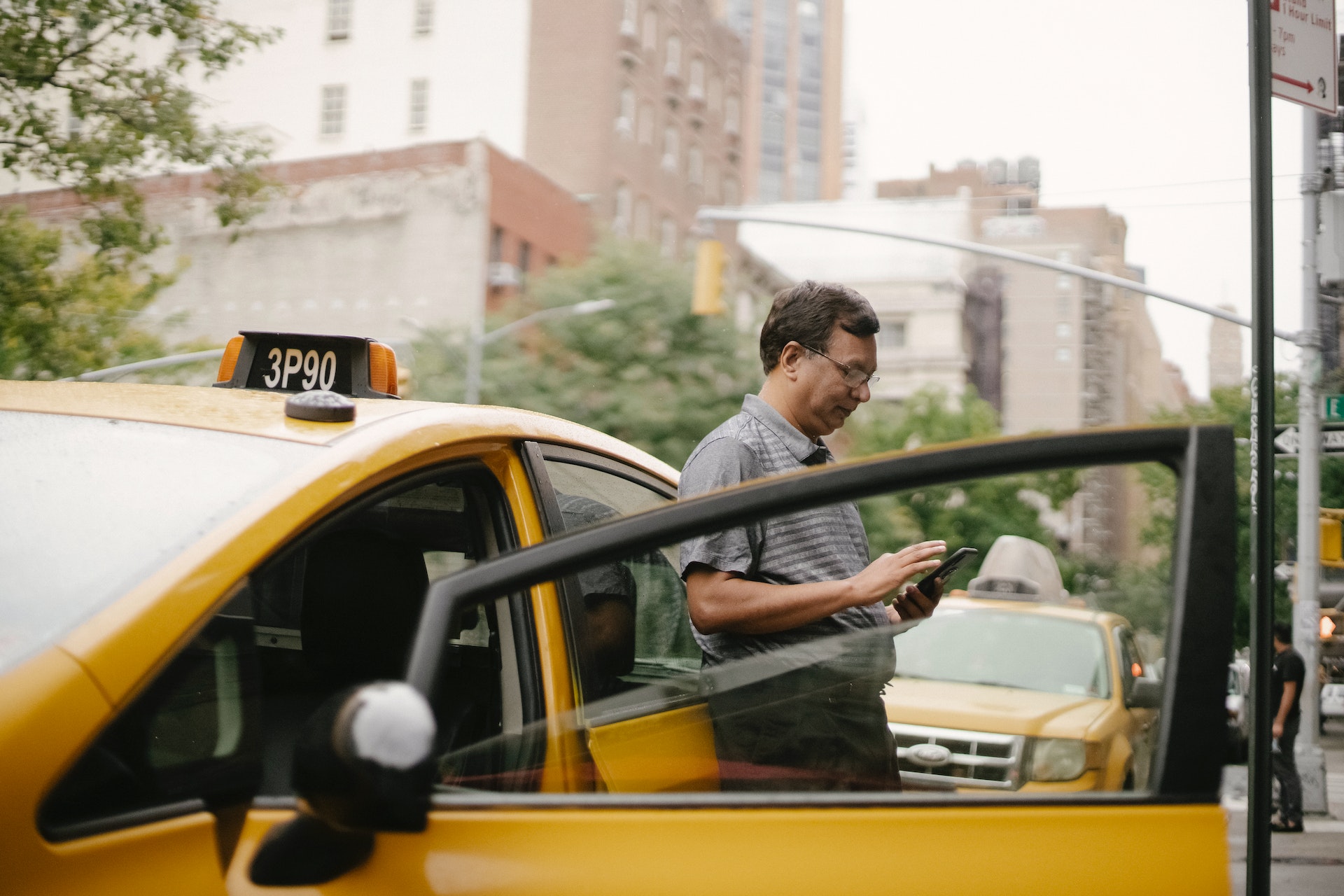 Un hombre apoyado en un taxi | Fuente: Pexels