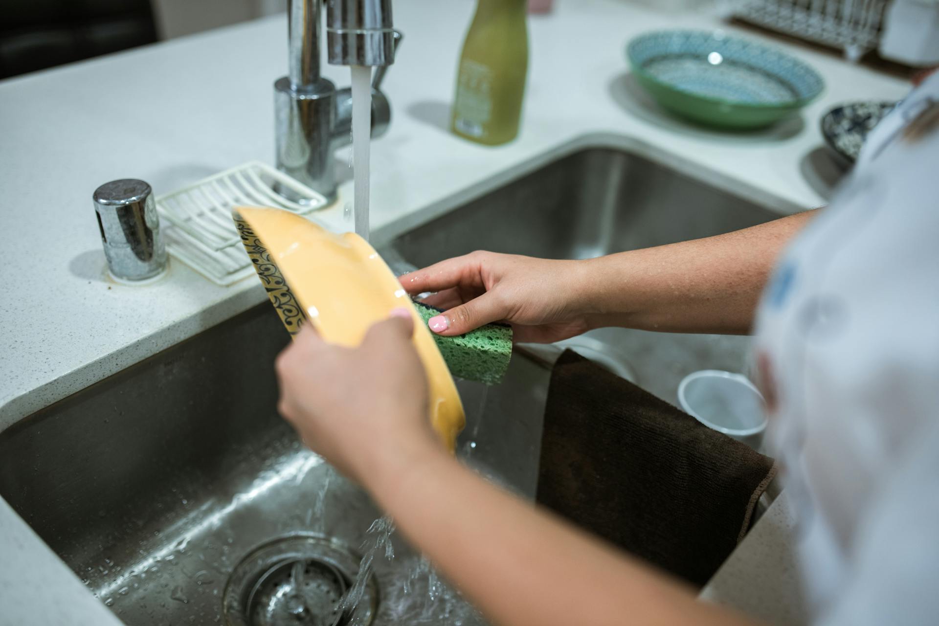 Una mujer lavando platos | Fuente: Pexels