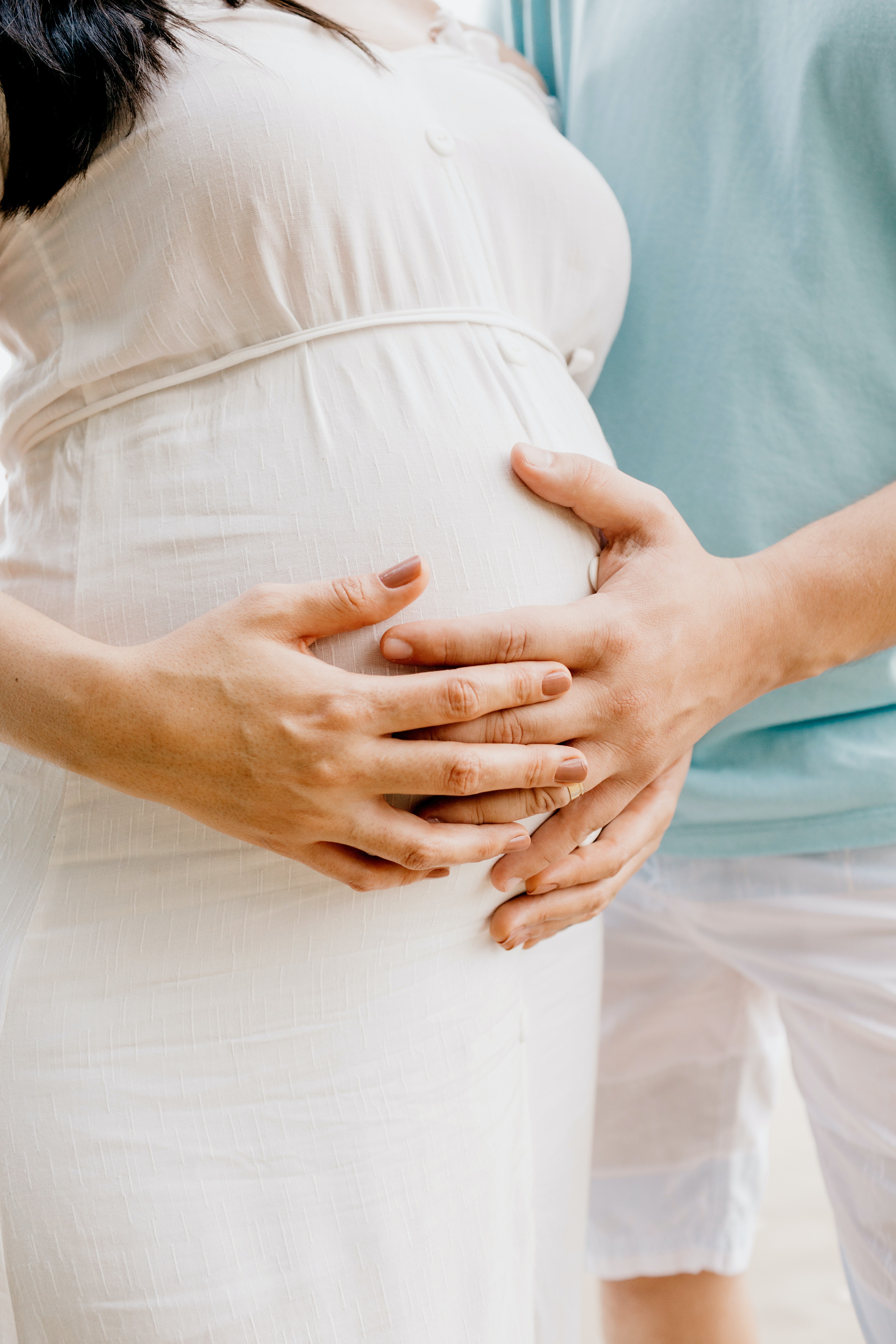Un par de manos sujetando un vientre de embarazada. | Foto: Pexels