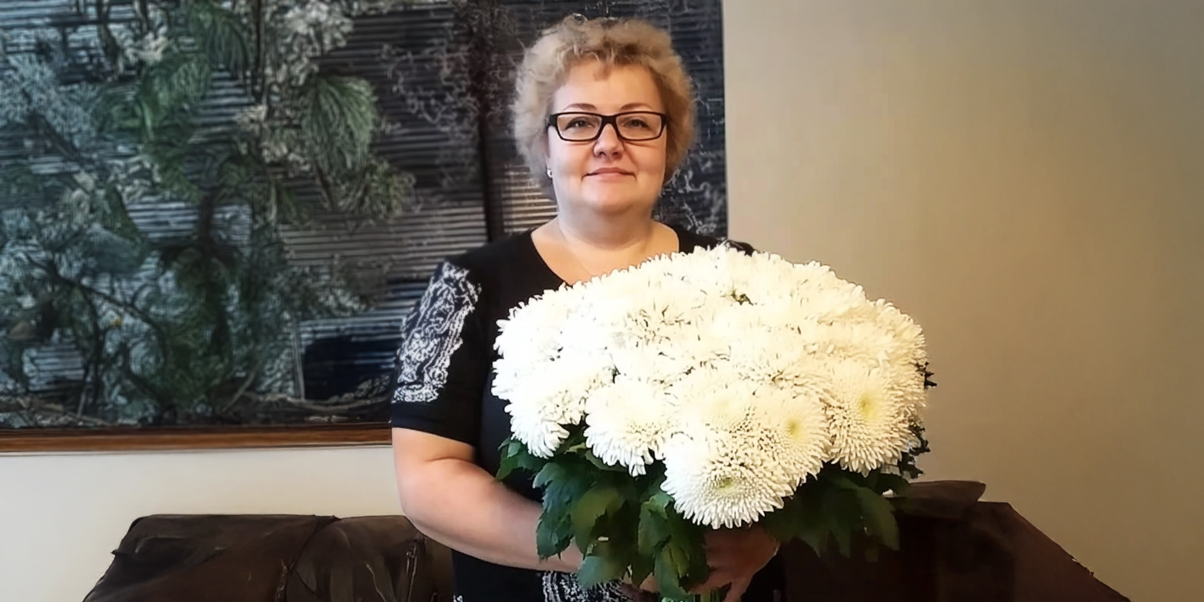 Una mujer mayor sonriente sosteniendo un ramo de flores | Fuente: AmoMama