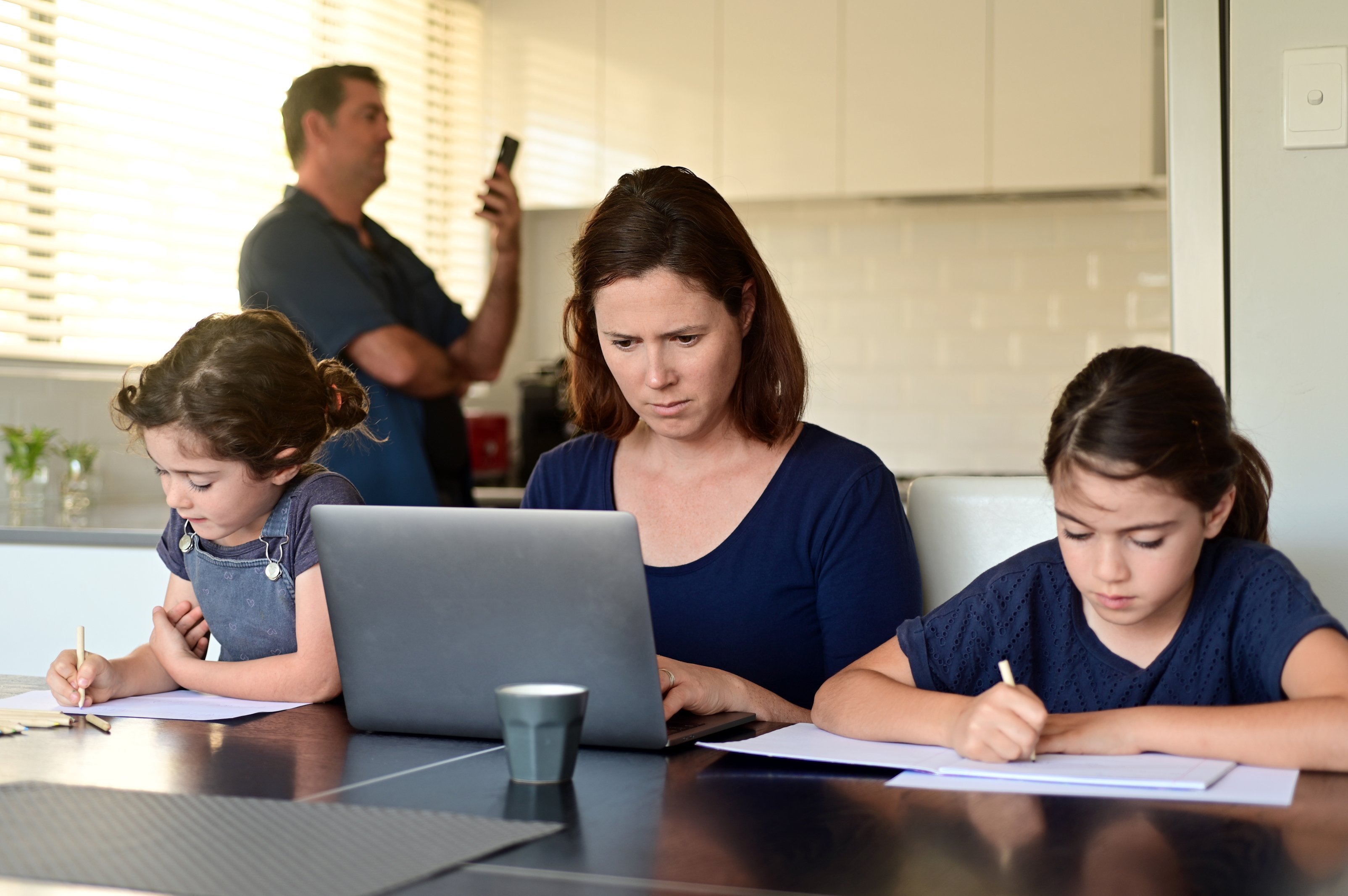 Padre, madre e hijas trabajando desde casa. | Foto: Shutterstock