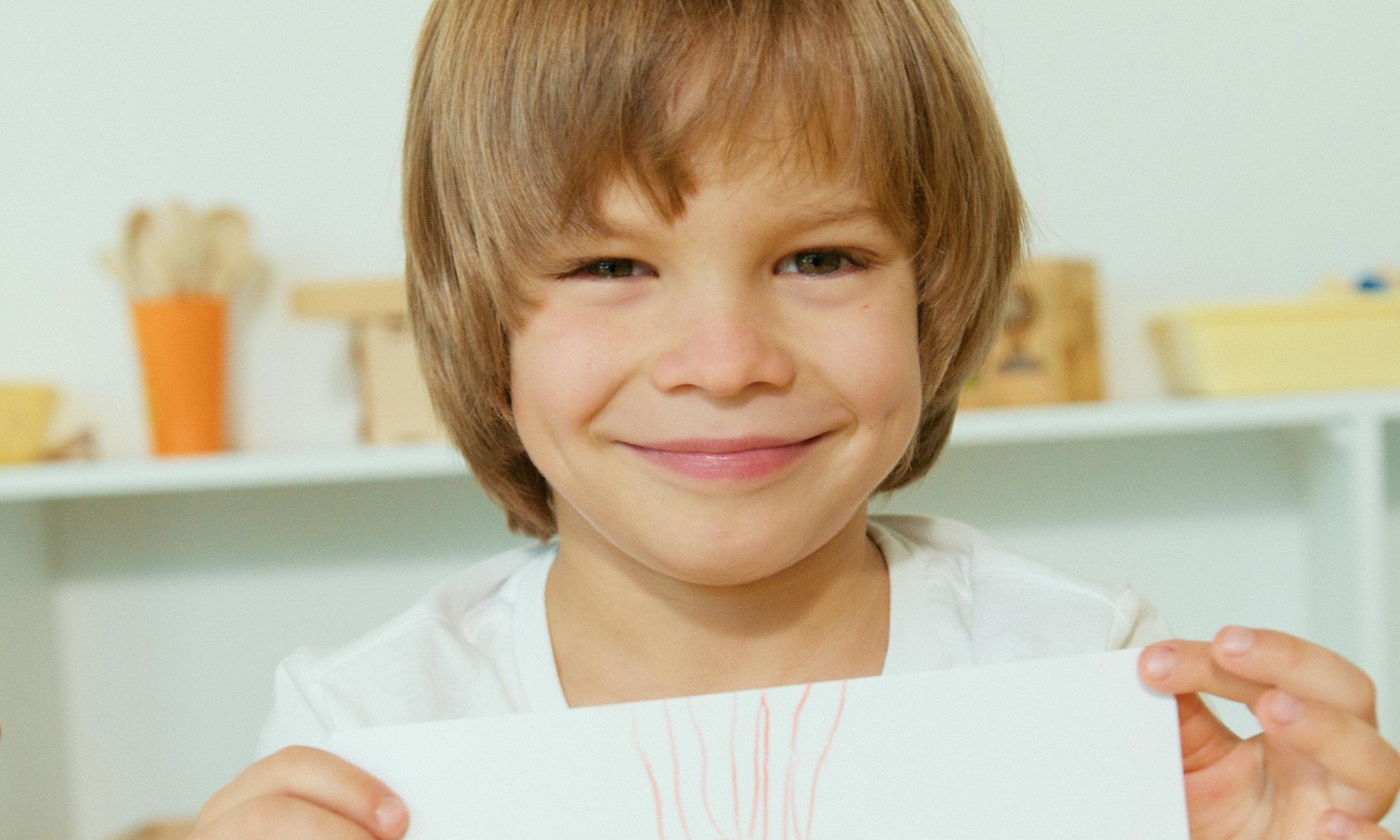 Un niño sonriente sostiene un dibujo | Fuente: Pexels