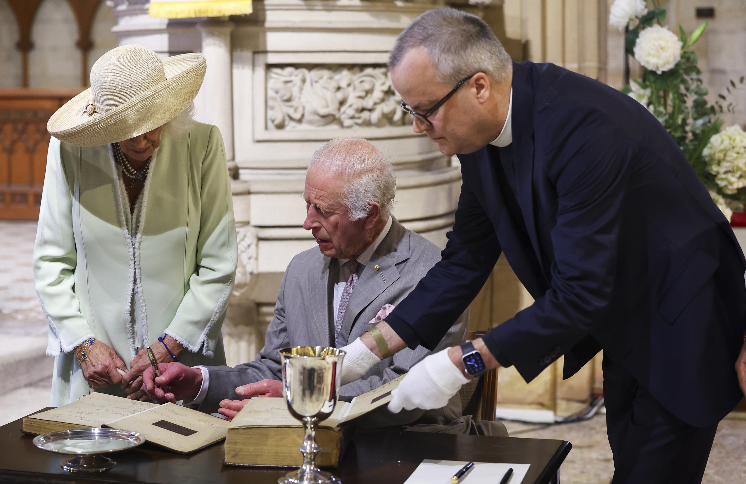 El rey Charles III y la reina Camilla observan el Libro de Oración Común durante una visita a la Iglesia Anglicana de Santo Tomás el 20 de octubre de 2024, en Sidney, Australia. | Fuente: Getty Images