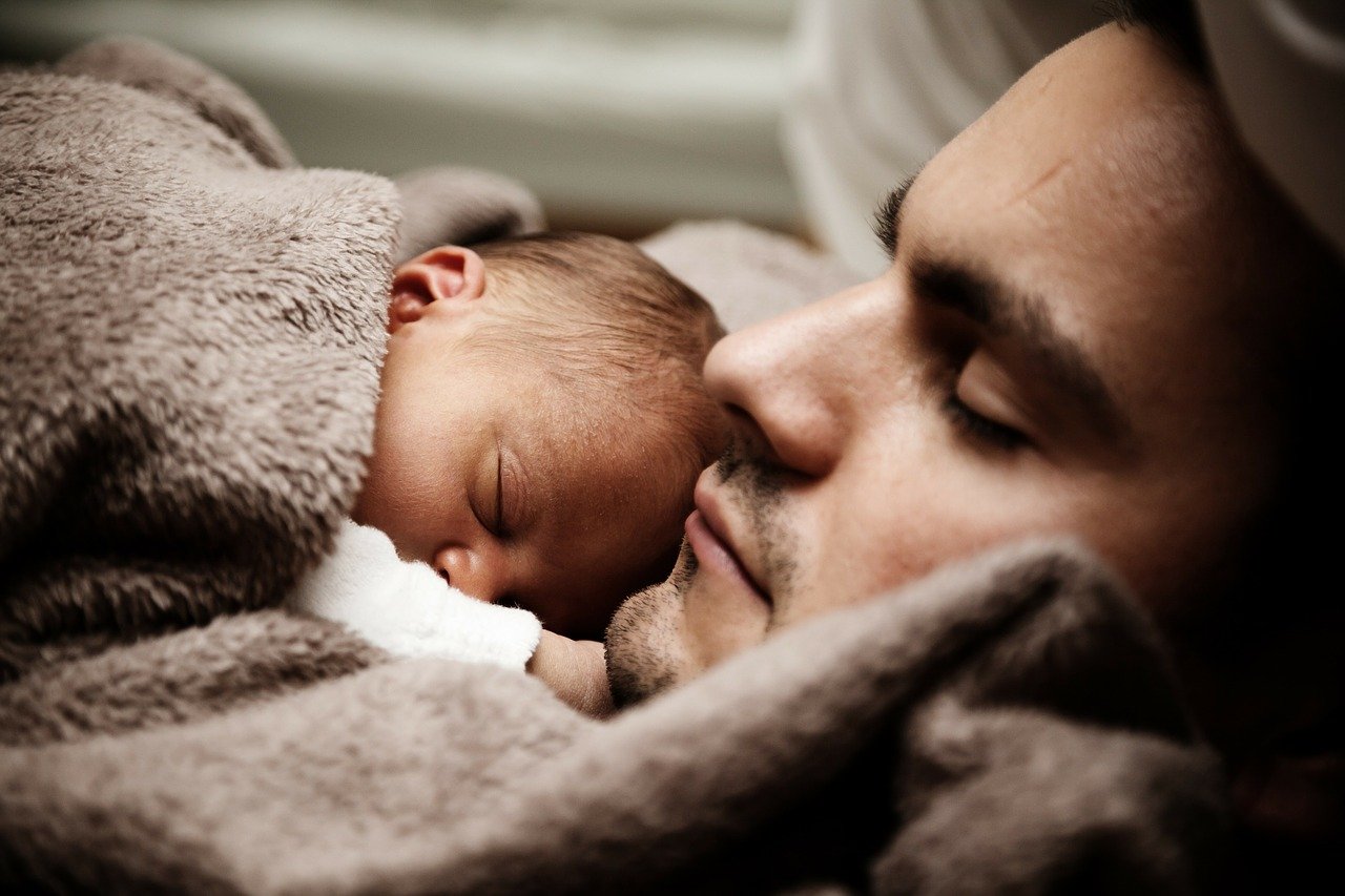 Un hombre durmiendo con un bebé apoyado en su pecho. | Foto: Pixabay / PublicDomainPictures