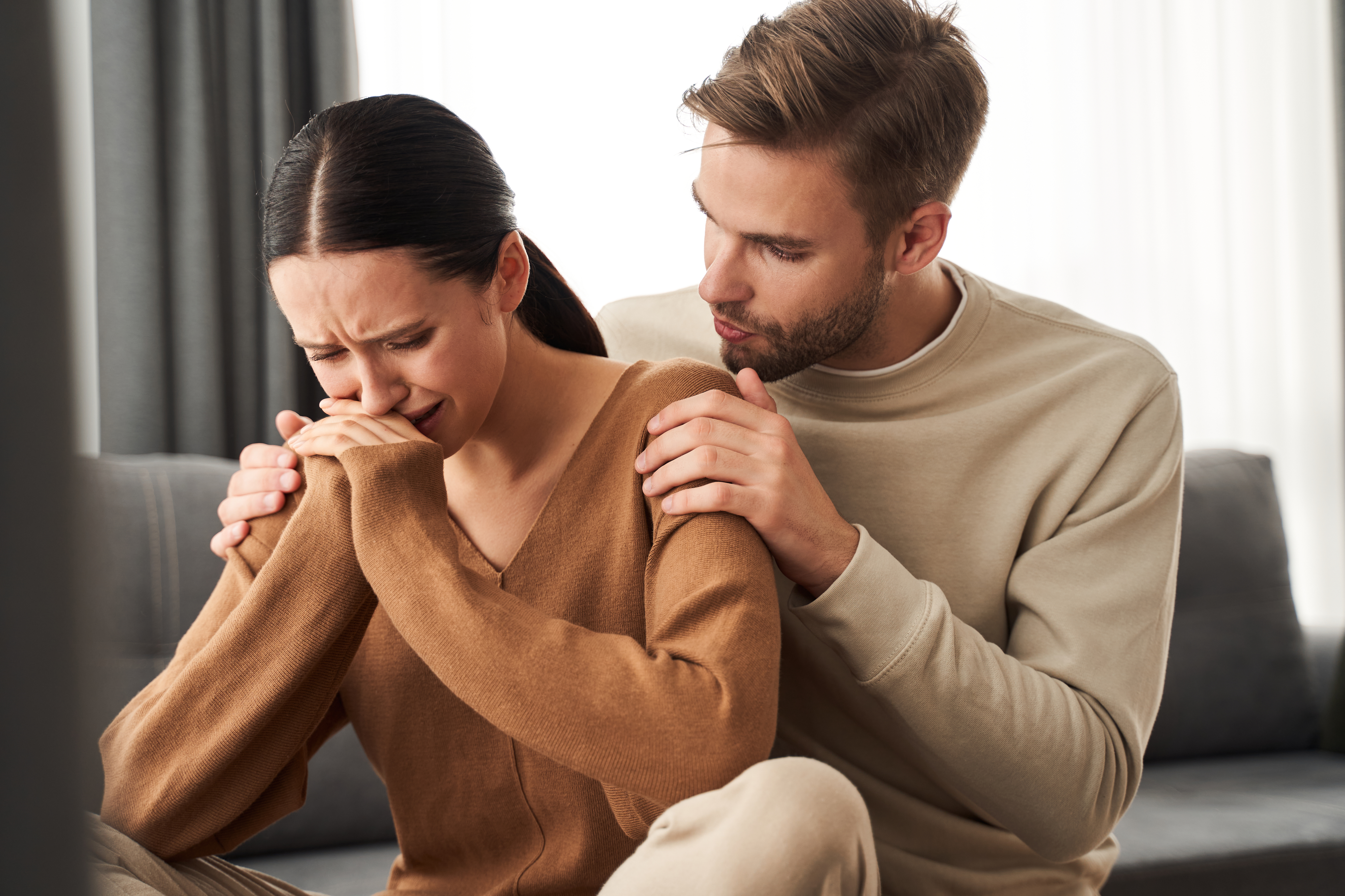 Un marido calmando a su mujer que llora | Fuente: Shutterstock