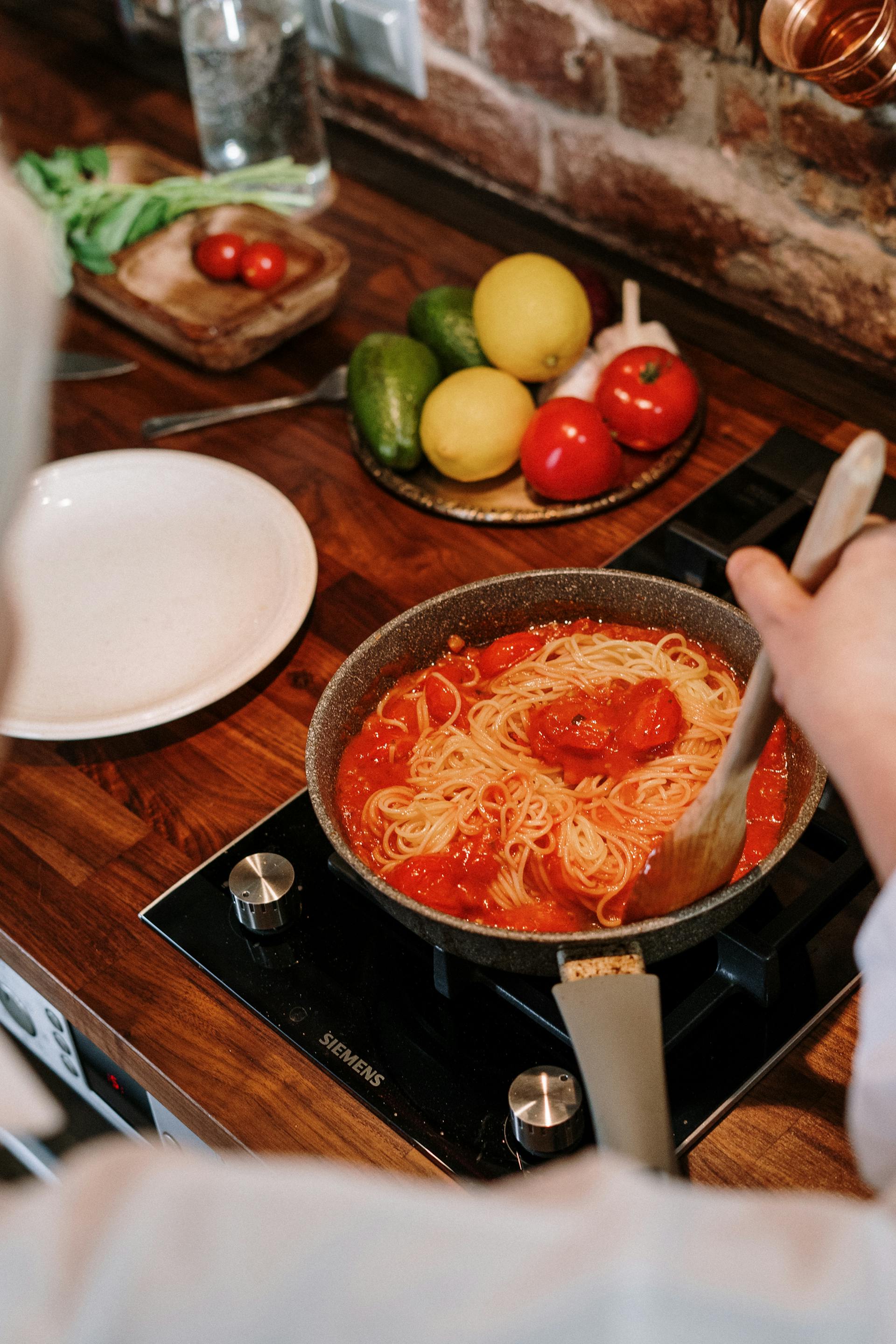 Primer plano de una mujer removiendo una olla en la cocina | Fuente: Pexels