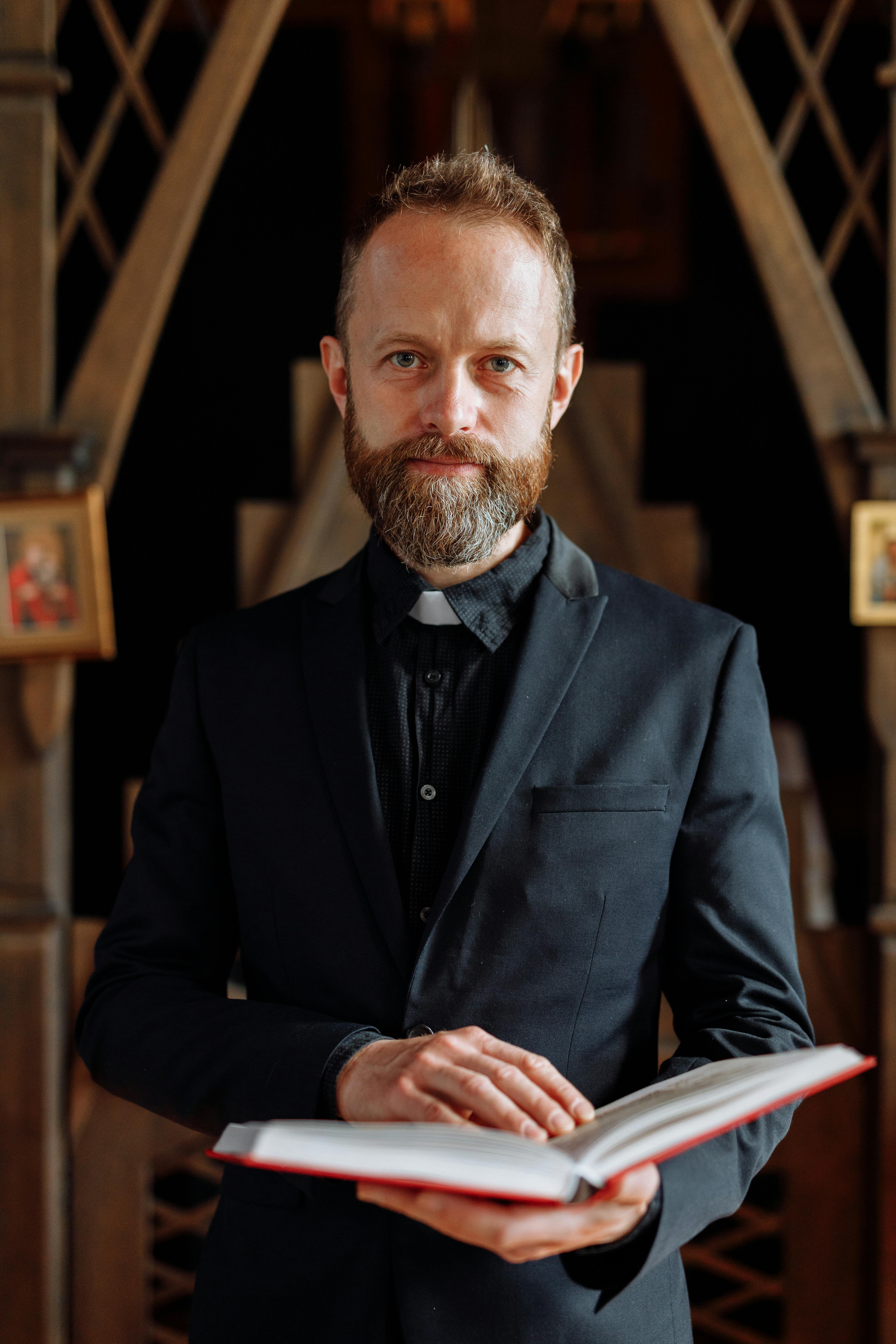 Un pastor sosteniendo una biblia | Fuente: Pexels
