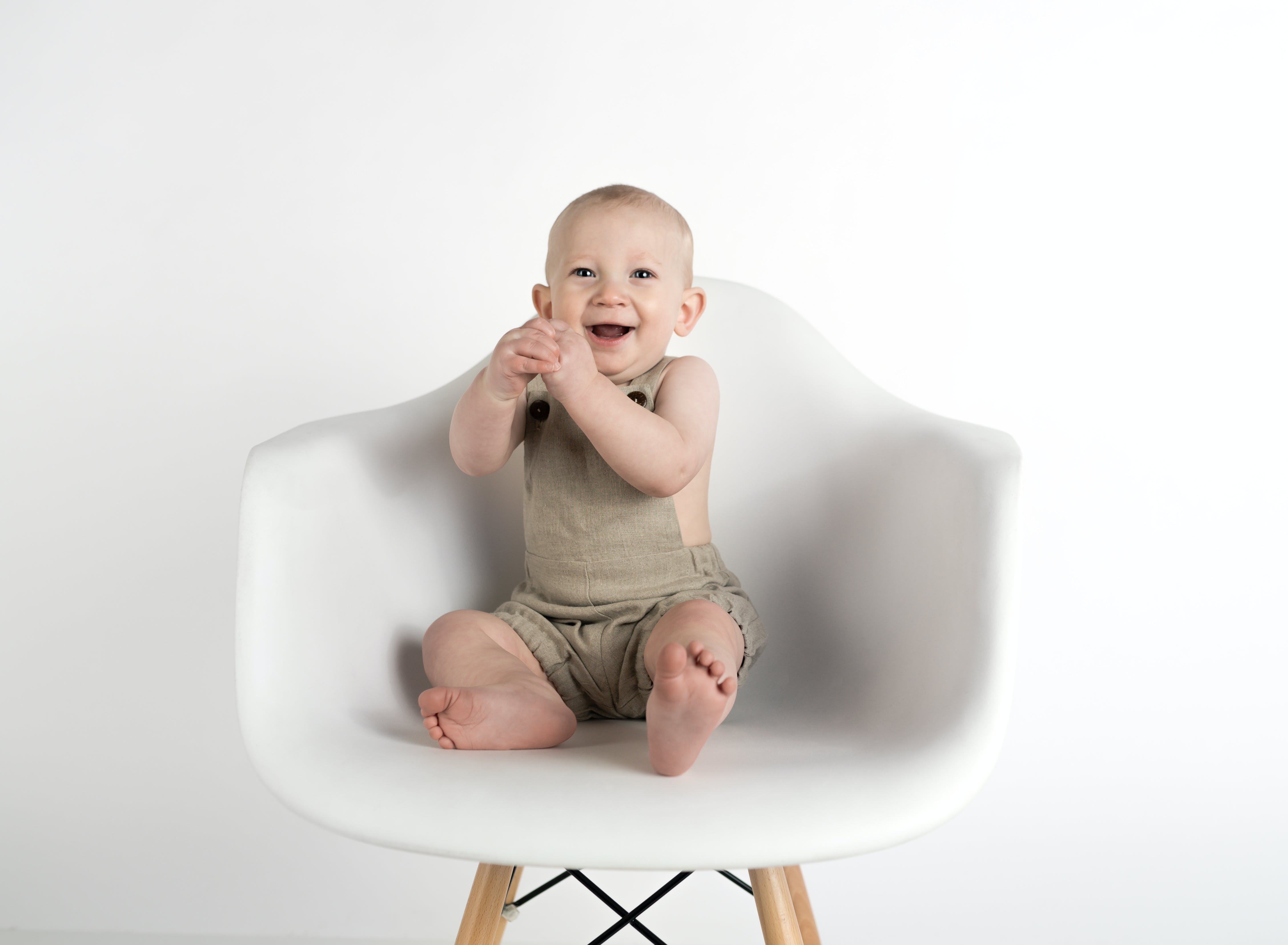 Un bebé riendo sentado en una silla | Foto: Pexels