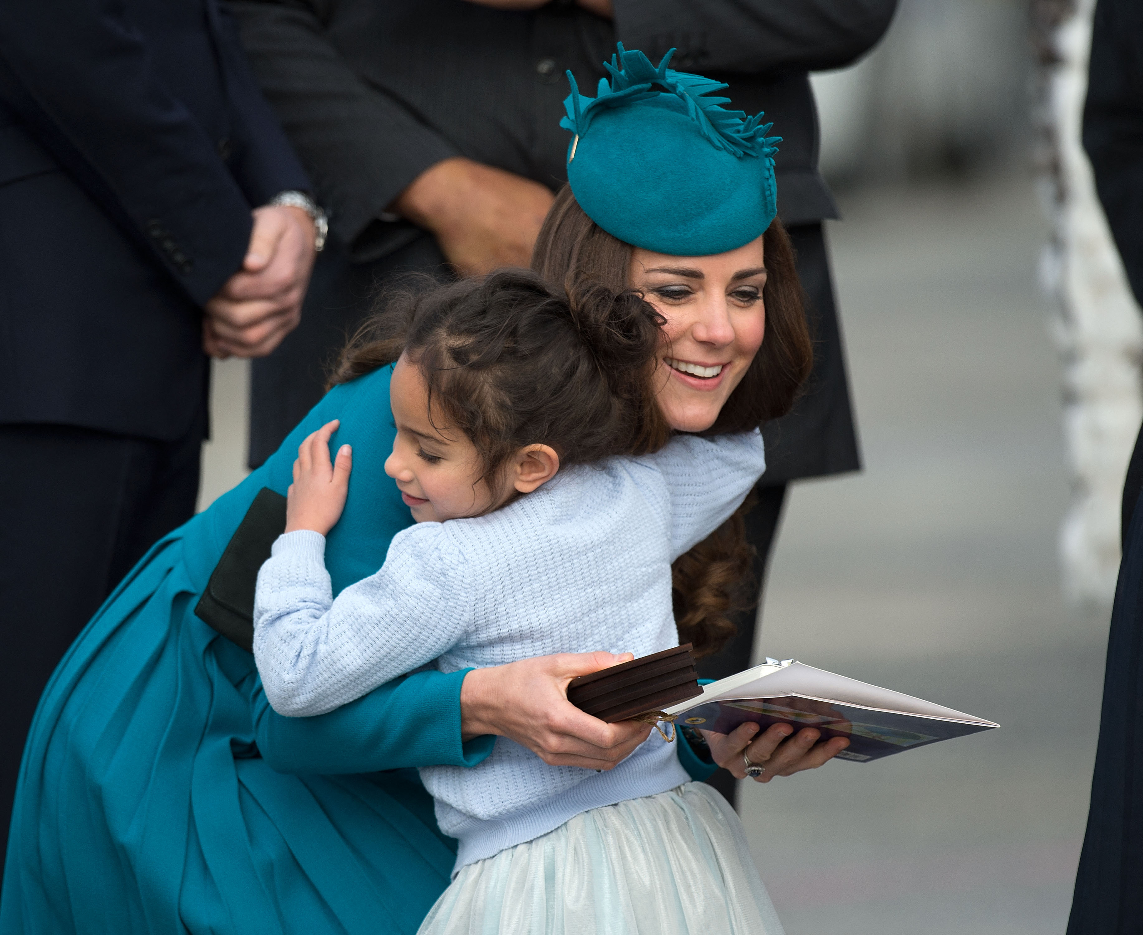 Catherine, la duquesa de Cambridge, recibe el abrazo de una niña durante la bienvenida maorí en el aeropuerto de Dunedin, el 13 de abril de 2014. | Fuente: Getty Images