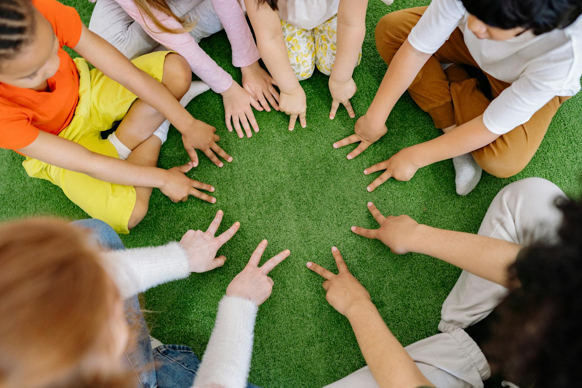 Niños sentados en la hierba | Fuente: Pexels