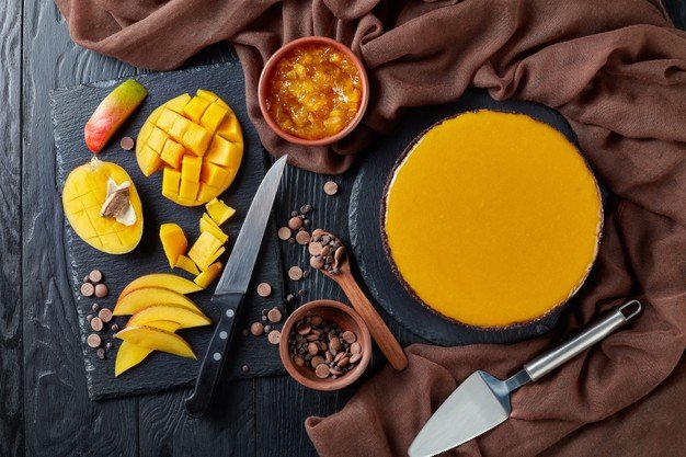 Tarta de mango con los ingredientes a un lado. │Foto: Freepik