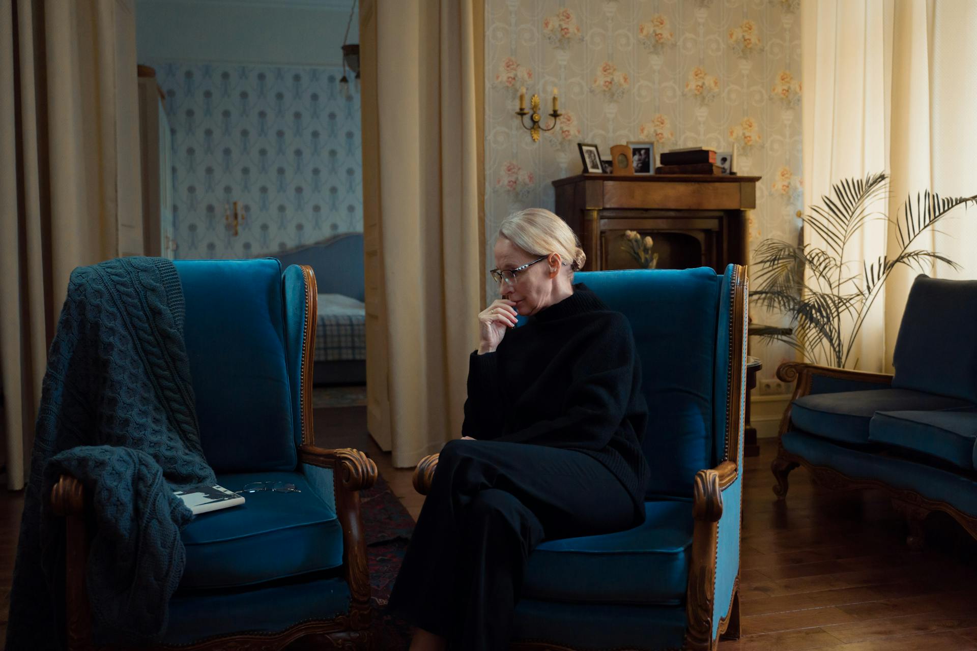 Una anciana sentada en un sofá azul | Fuente: Pexels