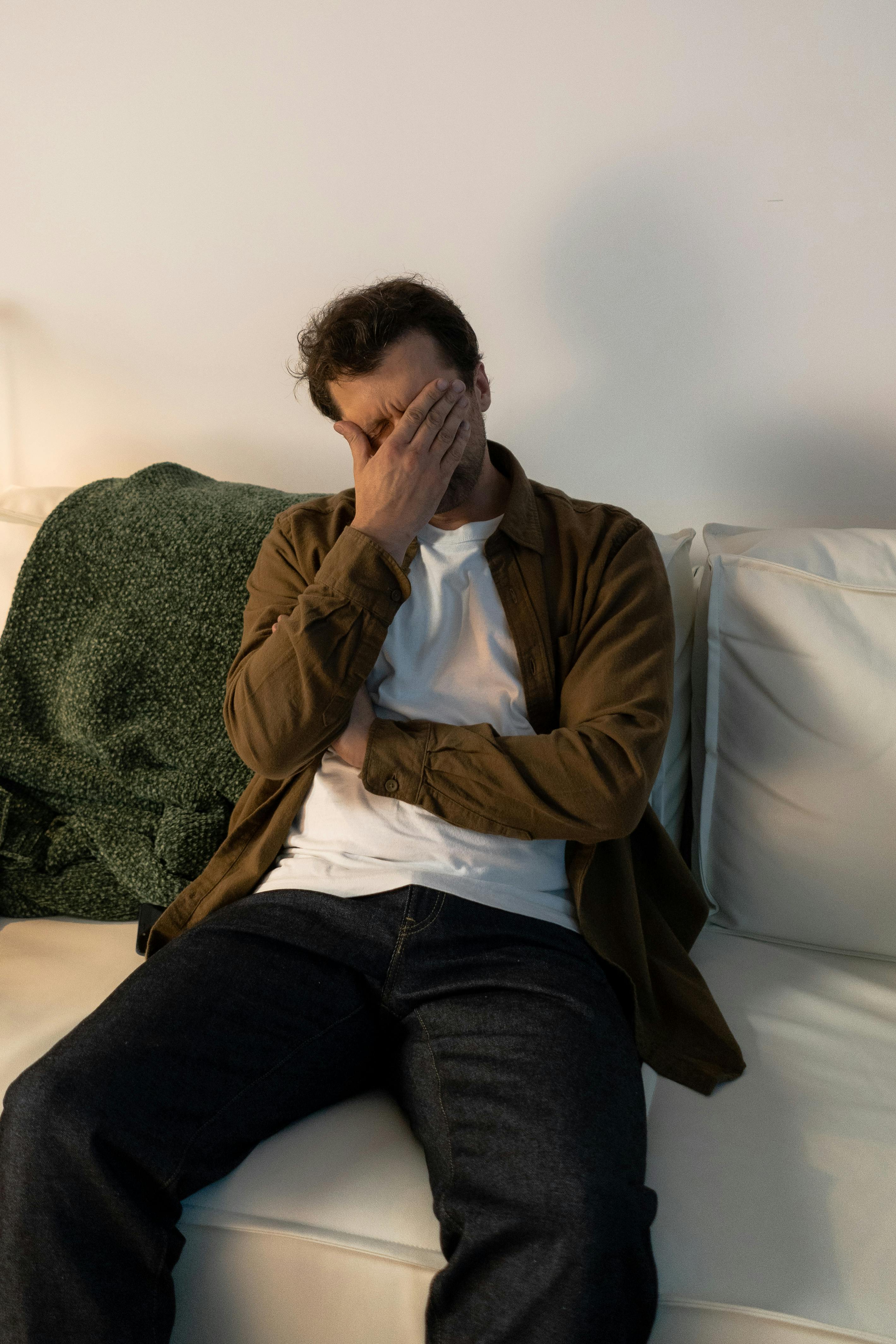 Un hombre angustiado sentado en un sofá | Fuente: Pexels