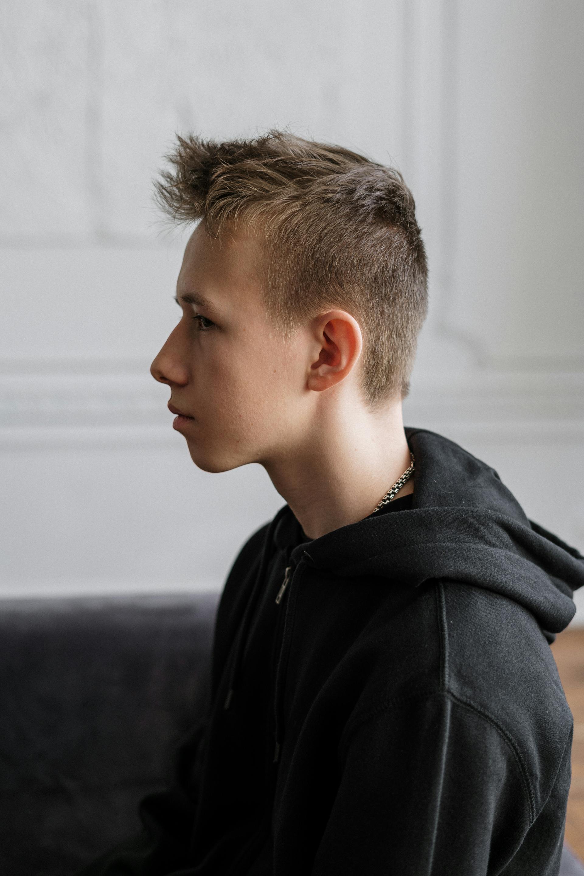 Un adolescente reflexivo en un sofá | Fuente: Pexels