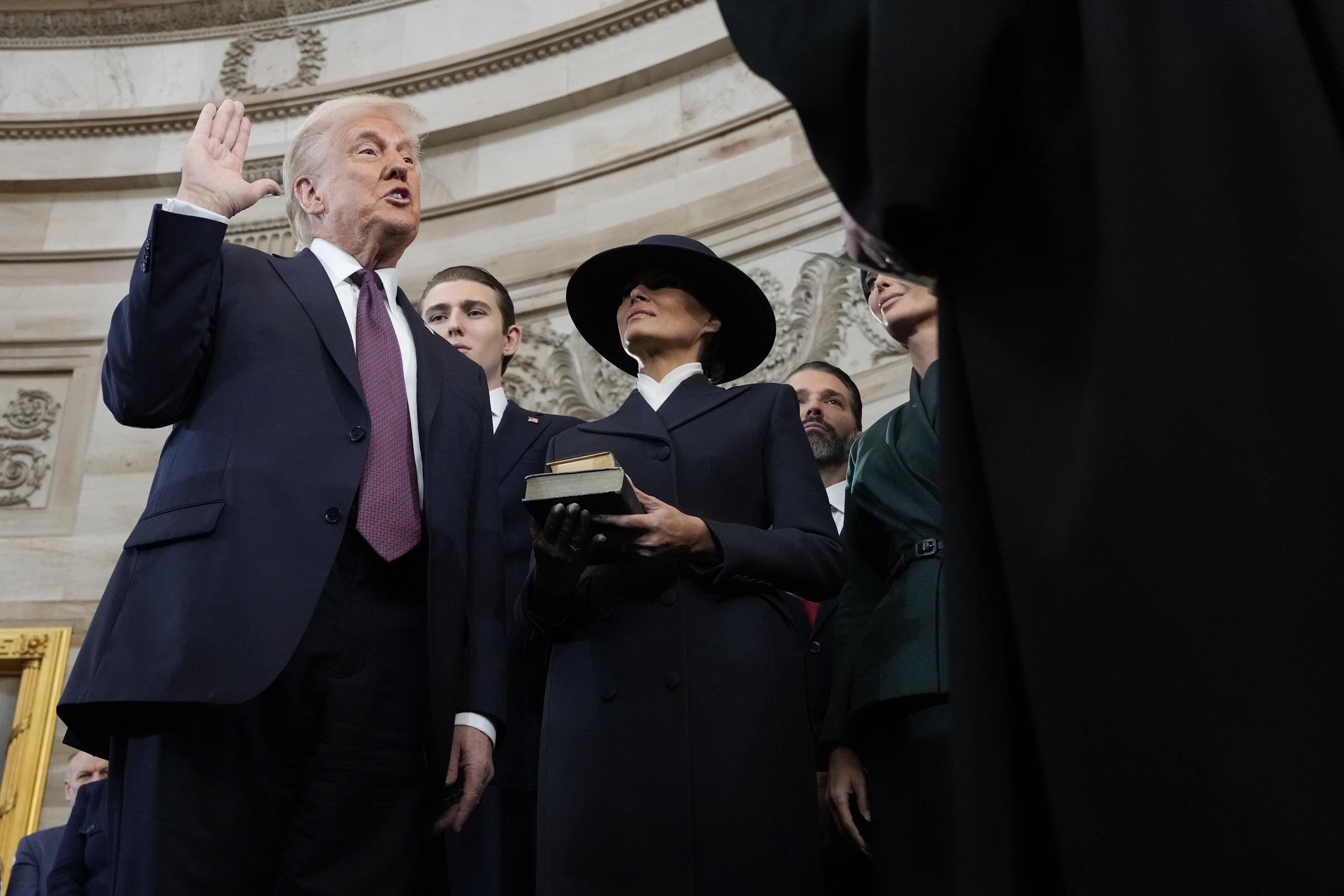 Donald Trump jura su cargo ante el presidente del Tribunal Supremo, John Roberts, ante la mirada de Barron y Melania Trump. | Fuente: Getty Images