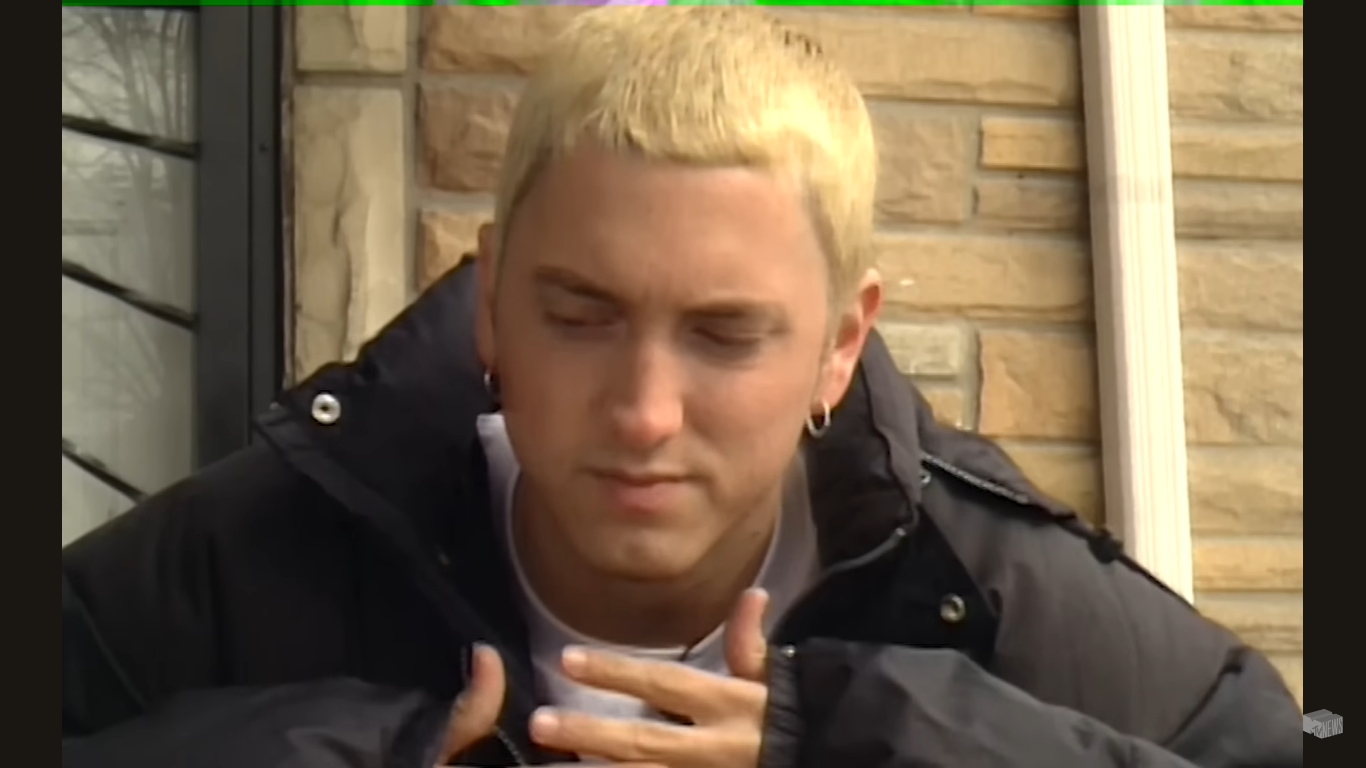Eminem en el exterior de su antigua casa de la infancia | Fuente: YouTube/WatchMojo