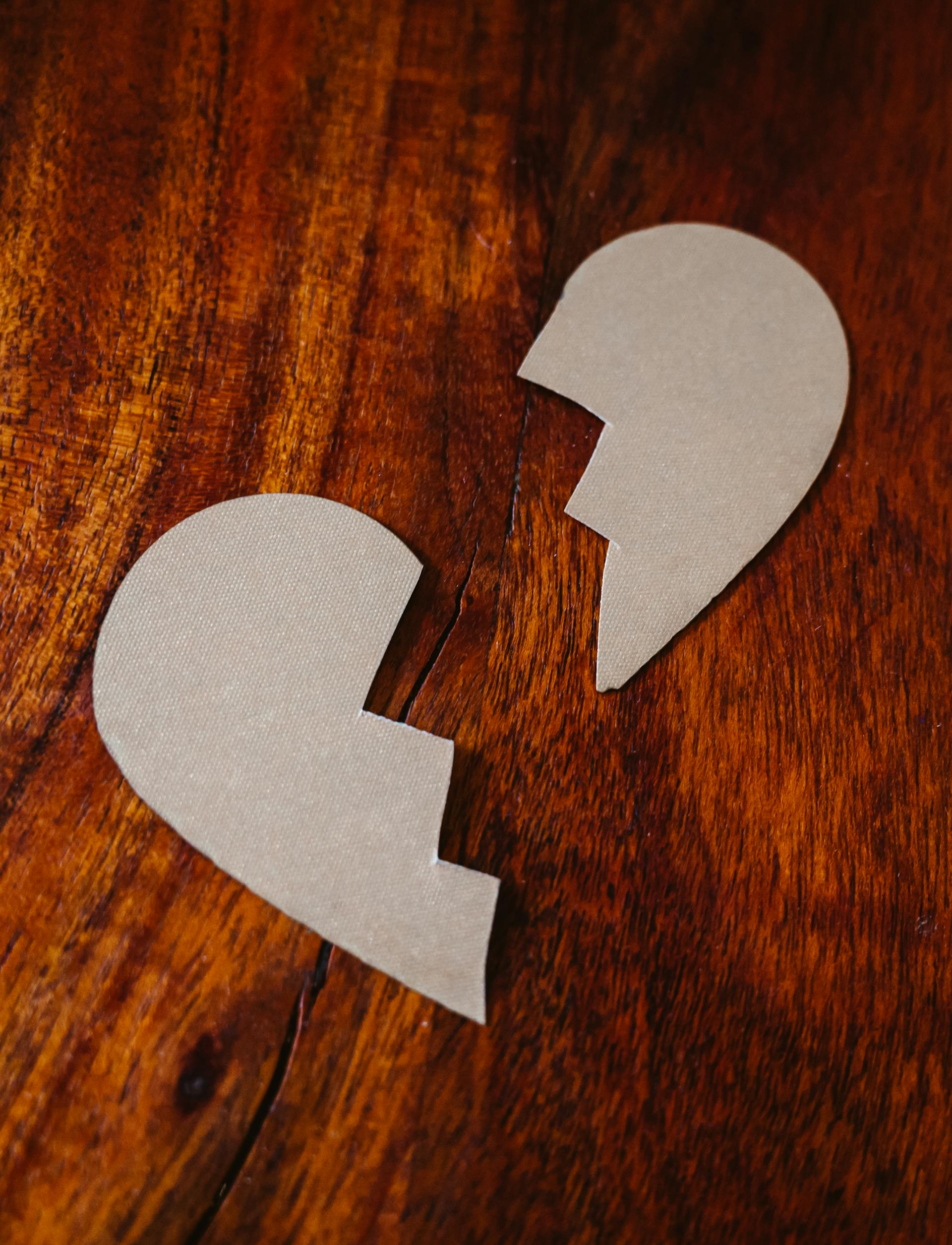 Un cartón con el corazón roto sobre una mesa de madera | Foto: Pexels