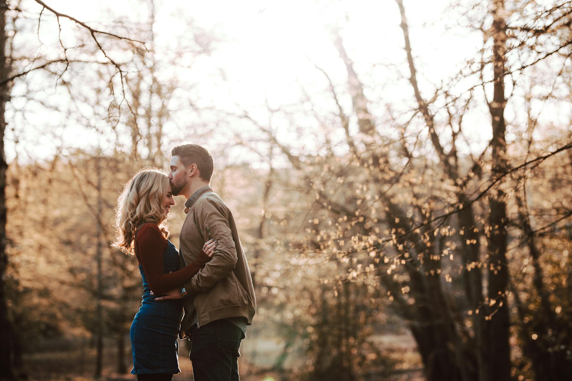 Una pareja de pie en un parque y besándose | Foto: Pexels