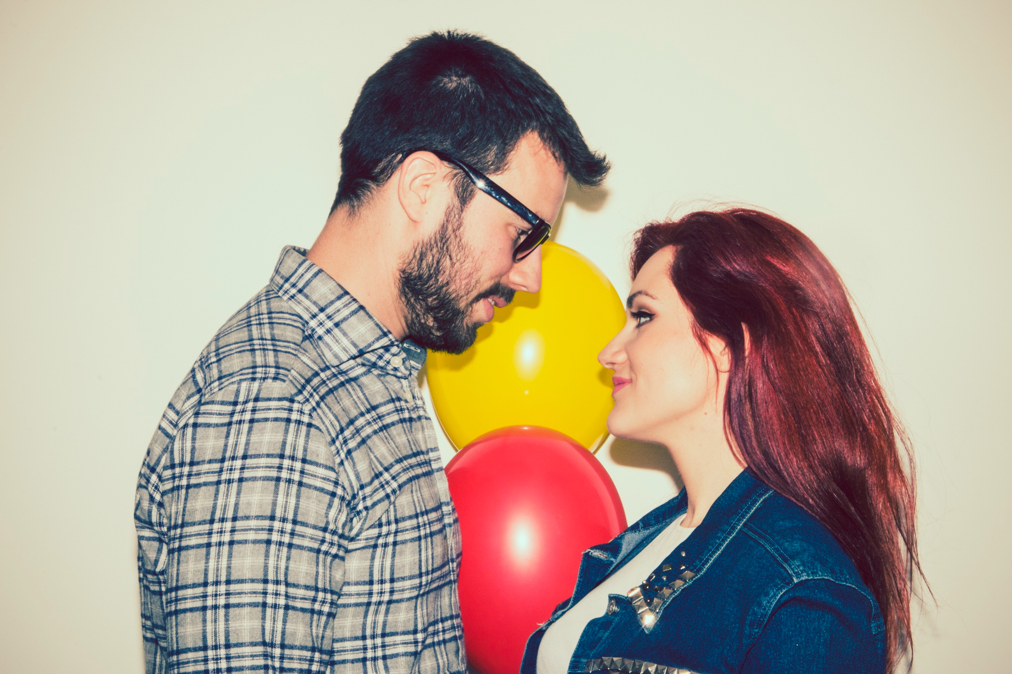 Una pareja mirándose con globos de fondo | Fuente: Freepik