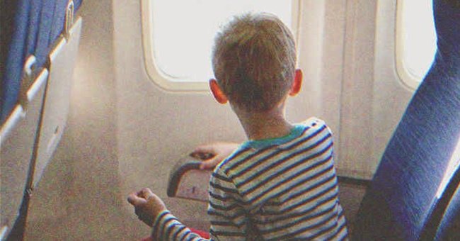 Niño mirando por la ventanilla de un avión | Fuente: Shutterstock