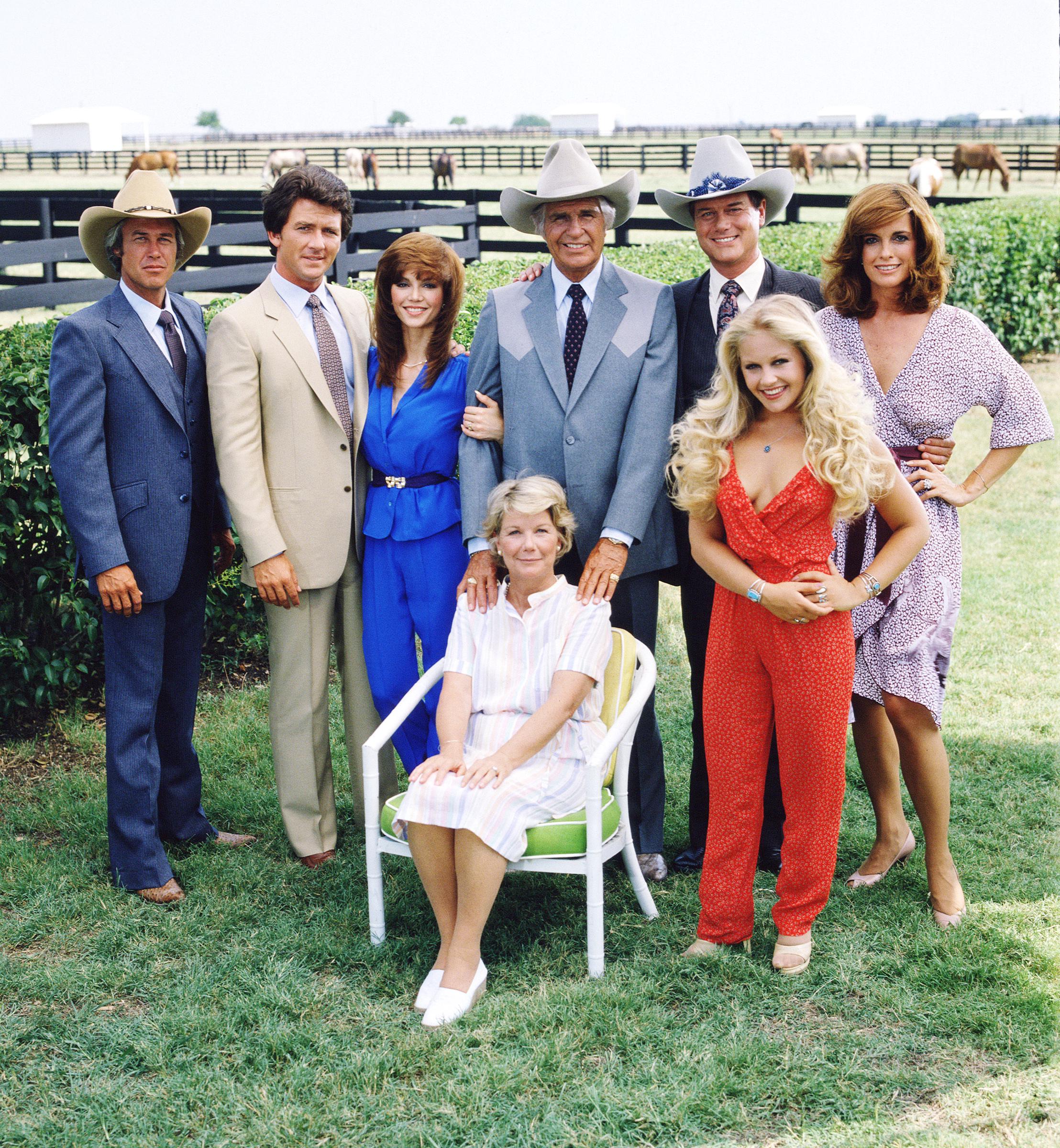 El reparto de "Dallas" reunido en la propiedad del rancho Southfork, en las afueras de Dallas, Texas, en 1979. De izquierda a derecha, Steve Kanaly, Patrick Duffy, Victoria Principal (sentada), Barbara Bel Geddes, Jim Davis, Larry Hagman, Charlene Tilton (de rojo) y Linda Gray | Fuente: Getty Images