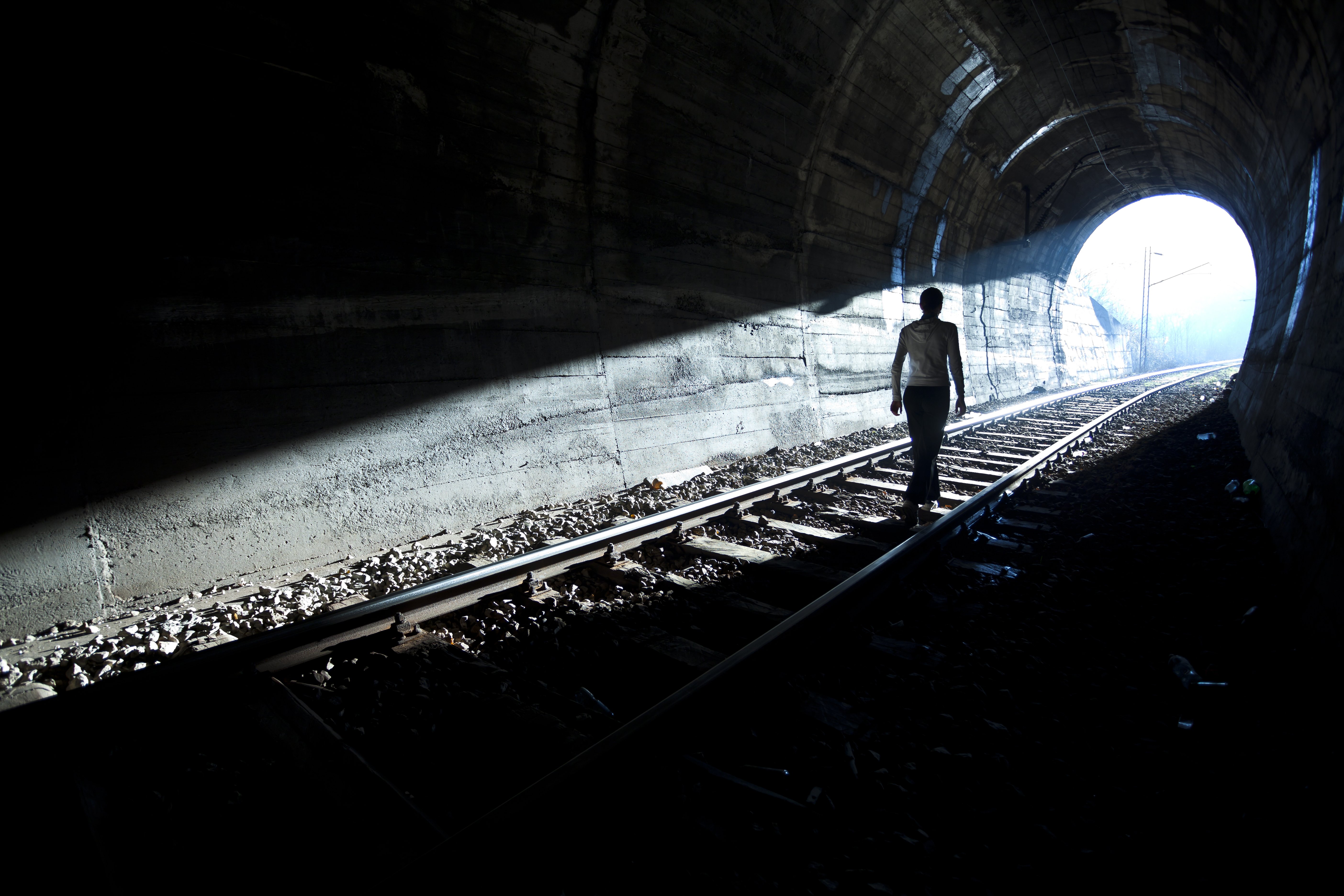 Mujer sigue la luz hasta salida del túnel. | Fuente: Shutterstock