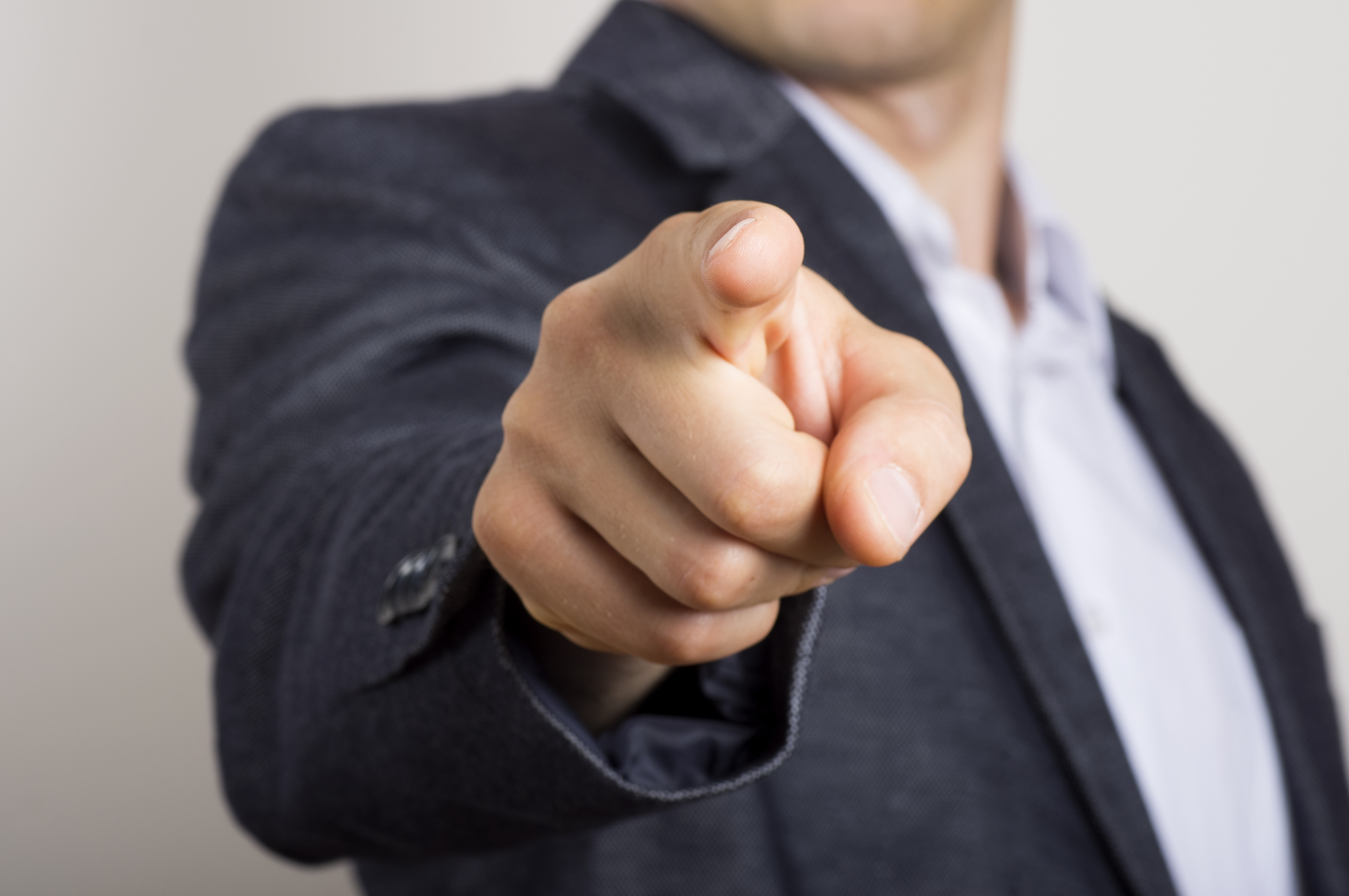 Un hombre de negocios señala a alguien con el dedo. | Fuente: Shutterstock