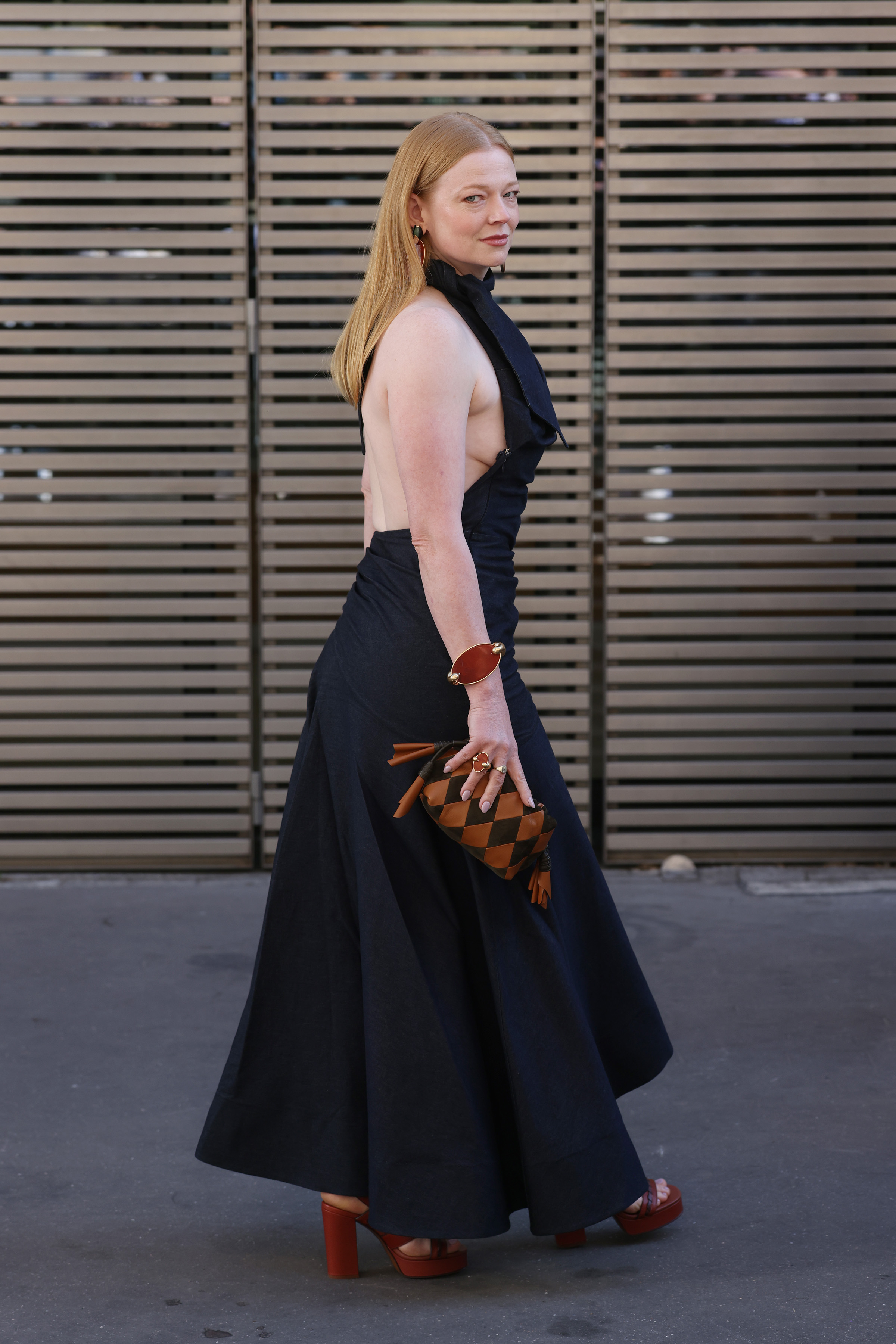 La espalda descubierta y la falda con vuelo le dan al vestido negro de Sarah Snook su silueta espectacular. Los complementos marrones le dan un toque más cálido al llegar a Zimmermann. | Fuente: Getty Images