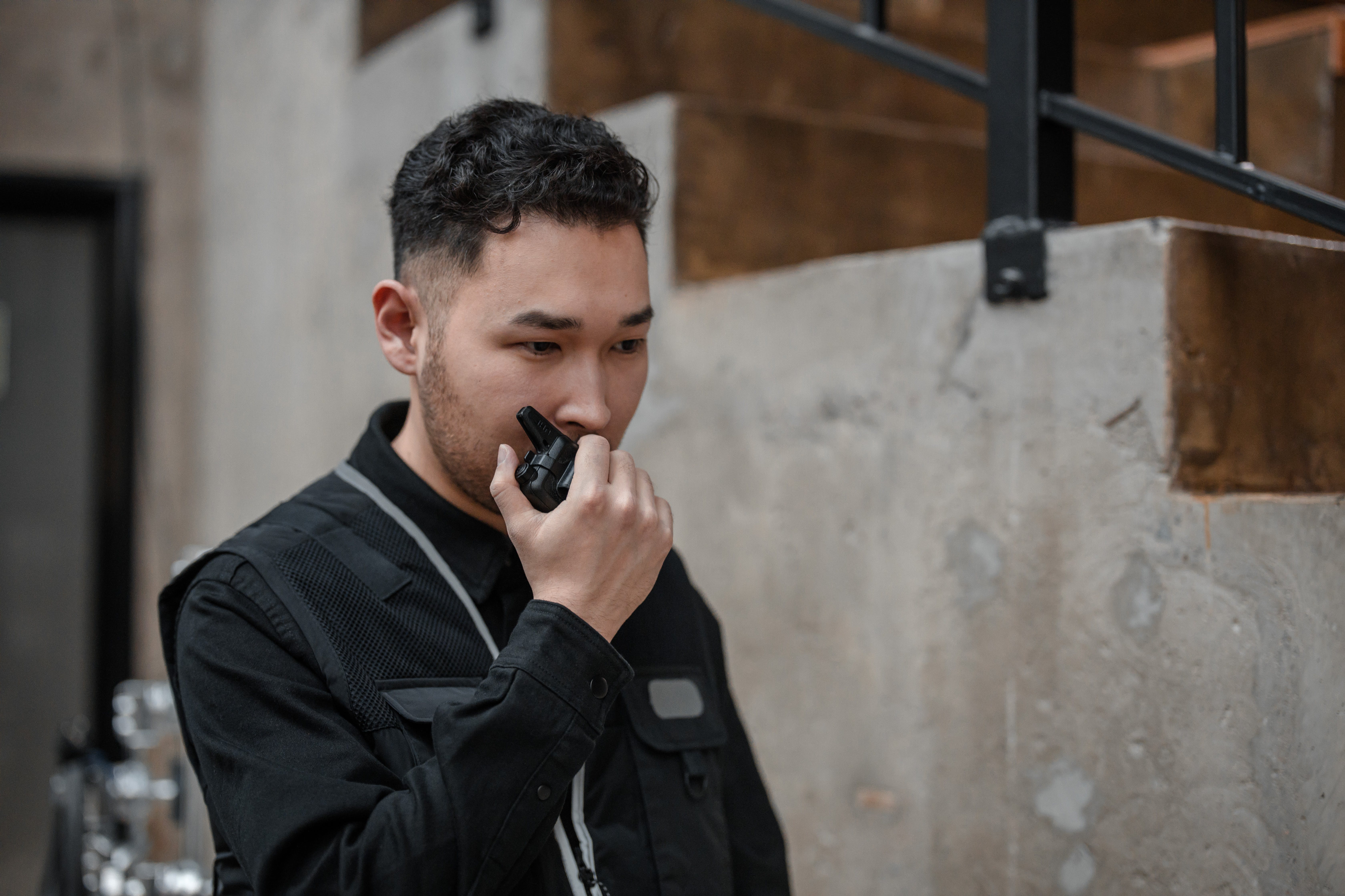 Un hombre de seguridad hablando por un walkie talkie. | Fuente: Pexels