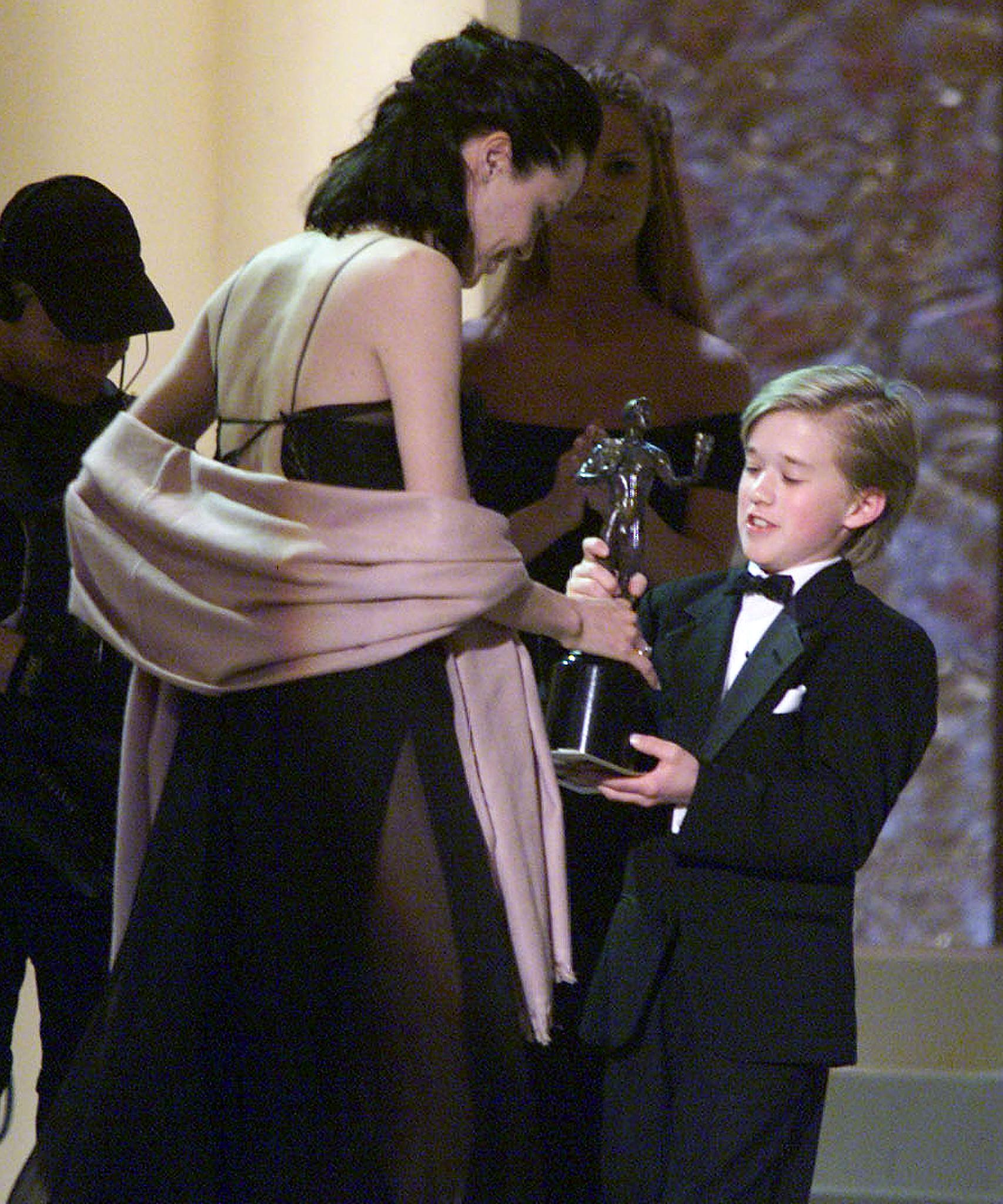 Angelina Jolie acepta su premio de manos de Haley Osment en la sexta entrega anual de los Screen Actors Guild Awards (SAG) el 12 de marzo de 2000 en Los Ángeles. | Fuente: Getty Images