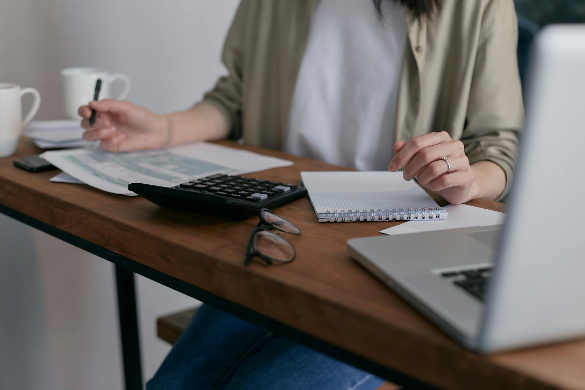 Una mujer trabajando con un bloc de notas y una calculadora | Fuente: Pexels