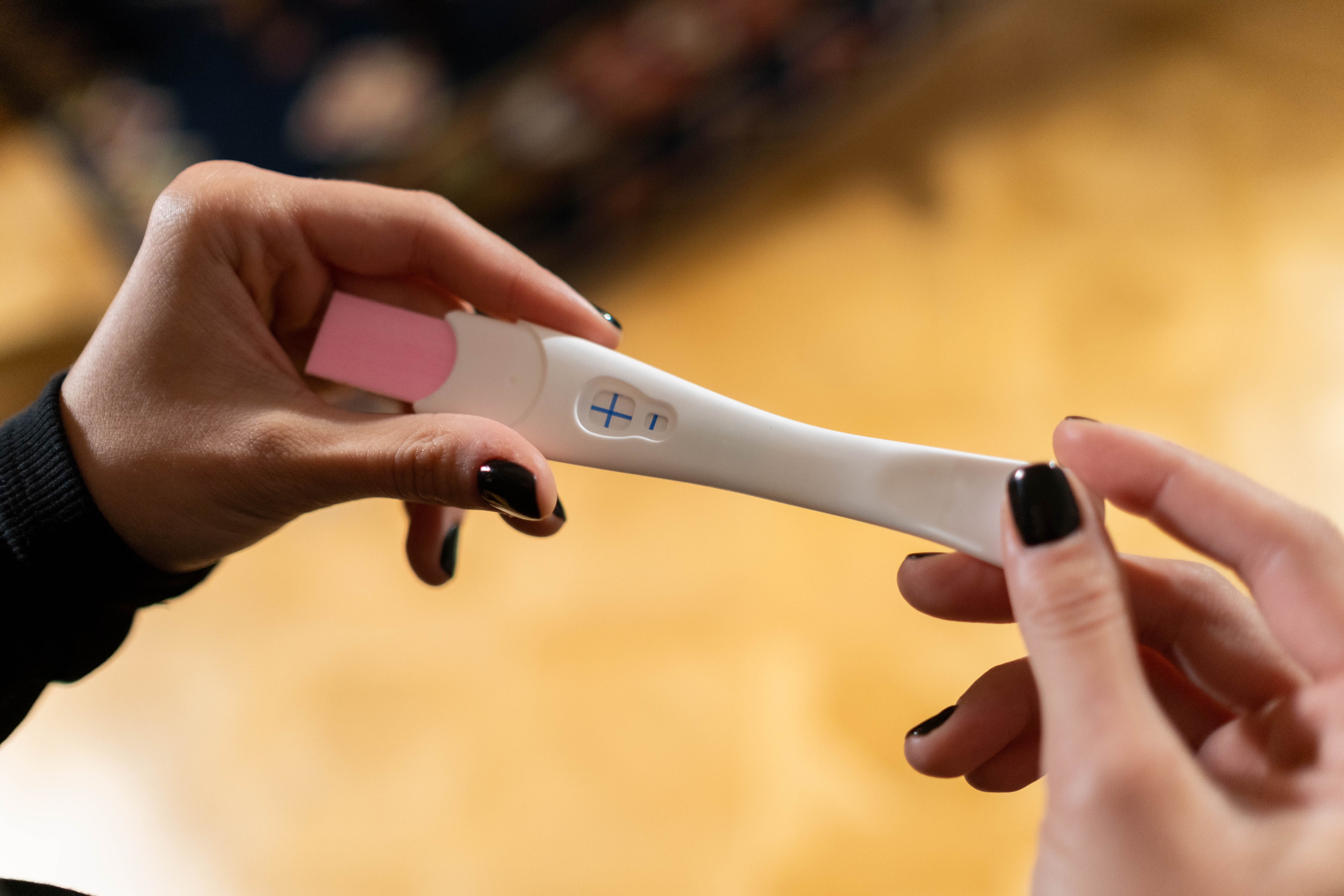Mujer sosteniendo una prueba de embarazo | Foto: Pexels
