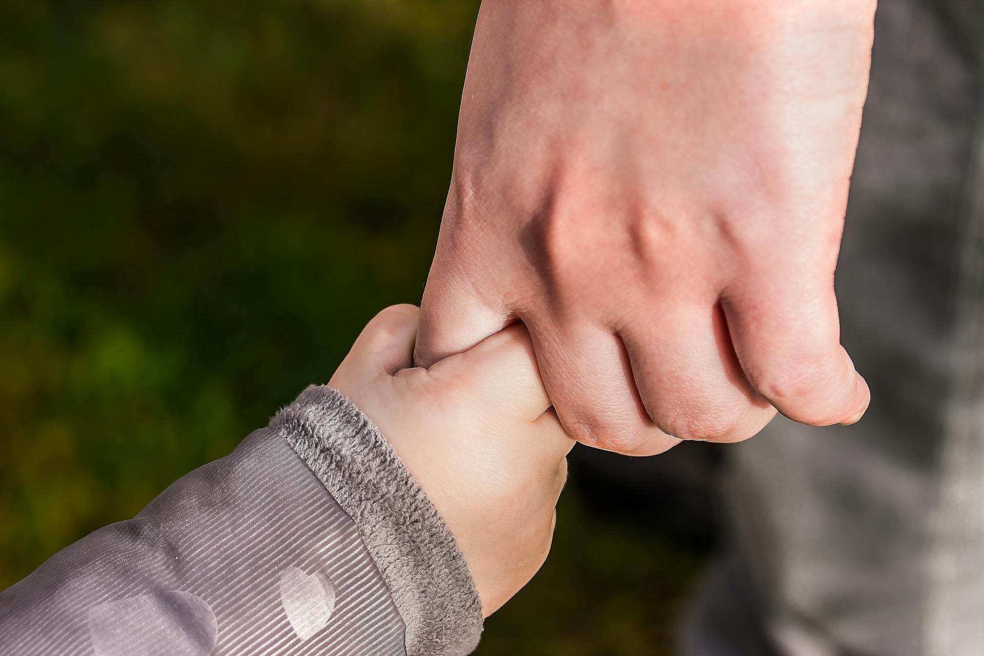 Una niña de la mano de un hombre | Fuente: Pexels