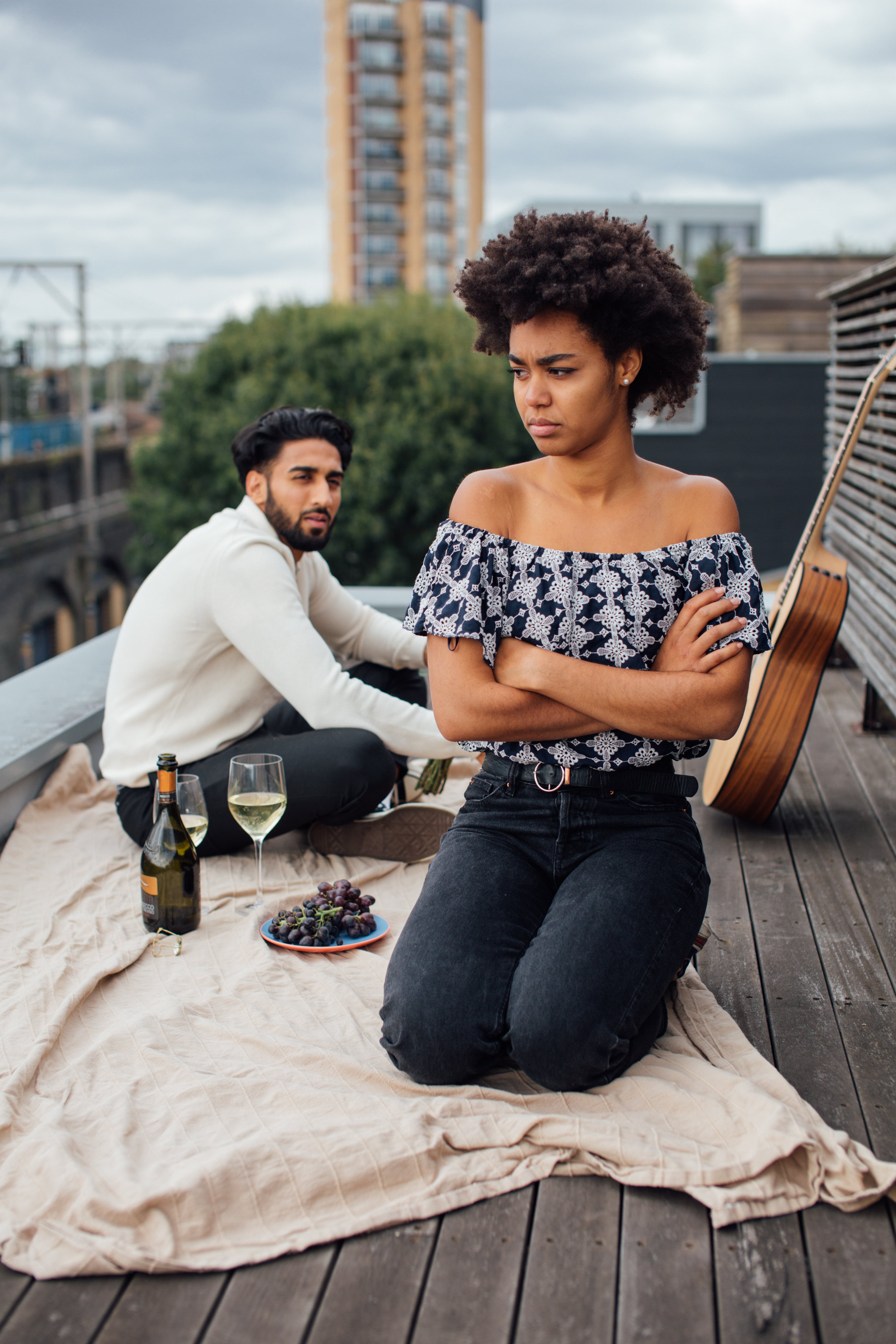 Una pareja birracial pasando un momento tenso mientras disfrutan de mientras y uvas | Fuente: Pexels