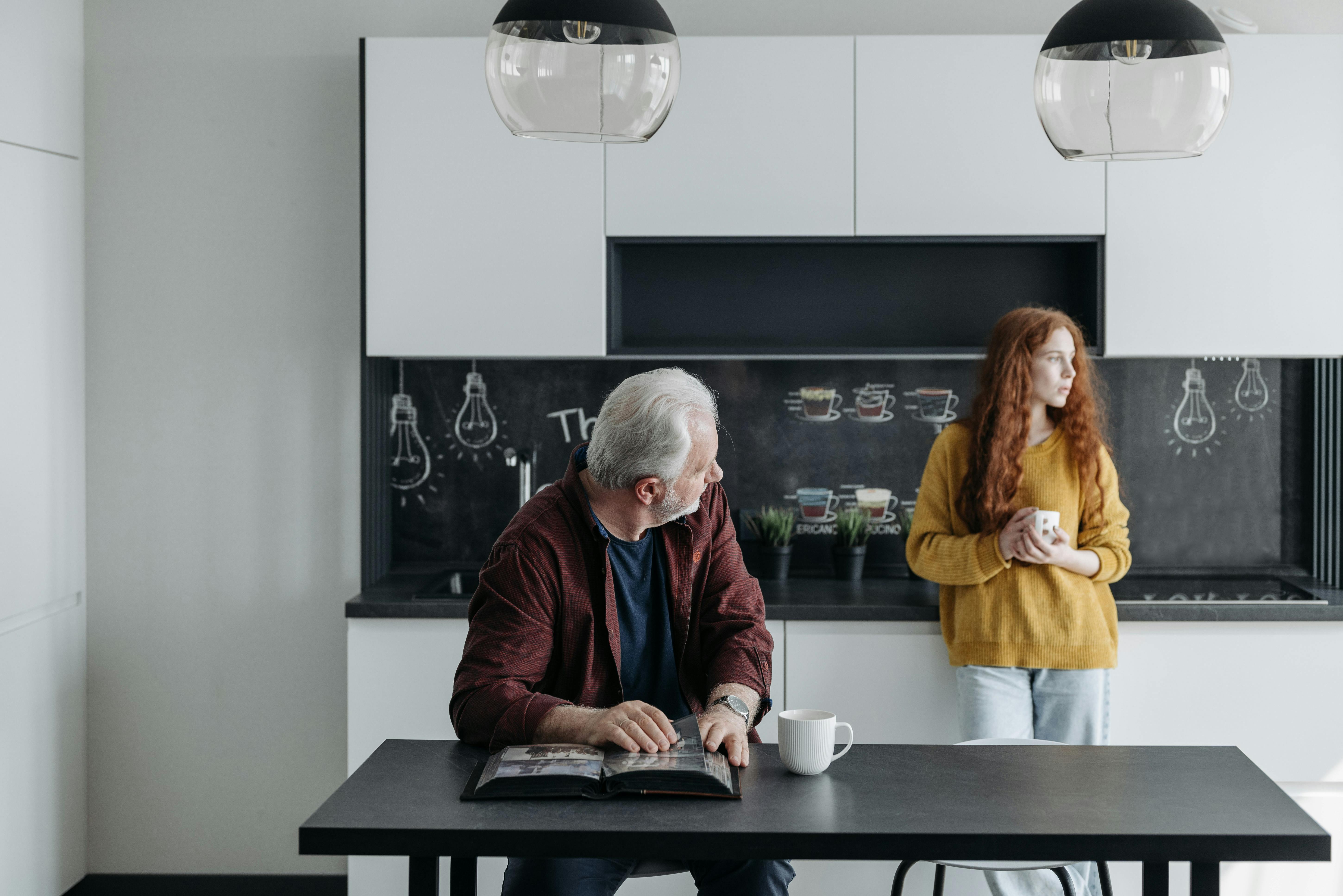 Un hombre sentado a la mesa mientras mira a una mujer | Fuente: Pexels