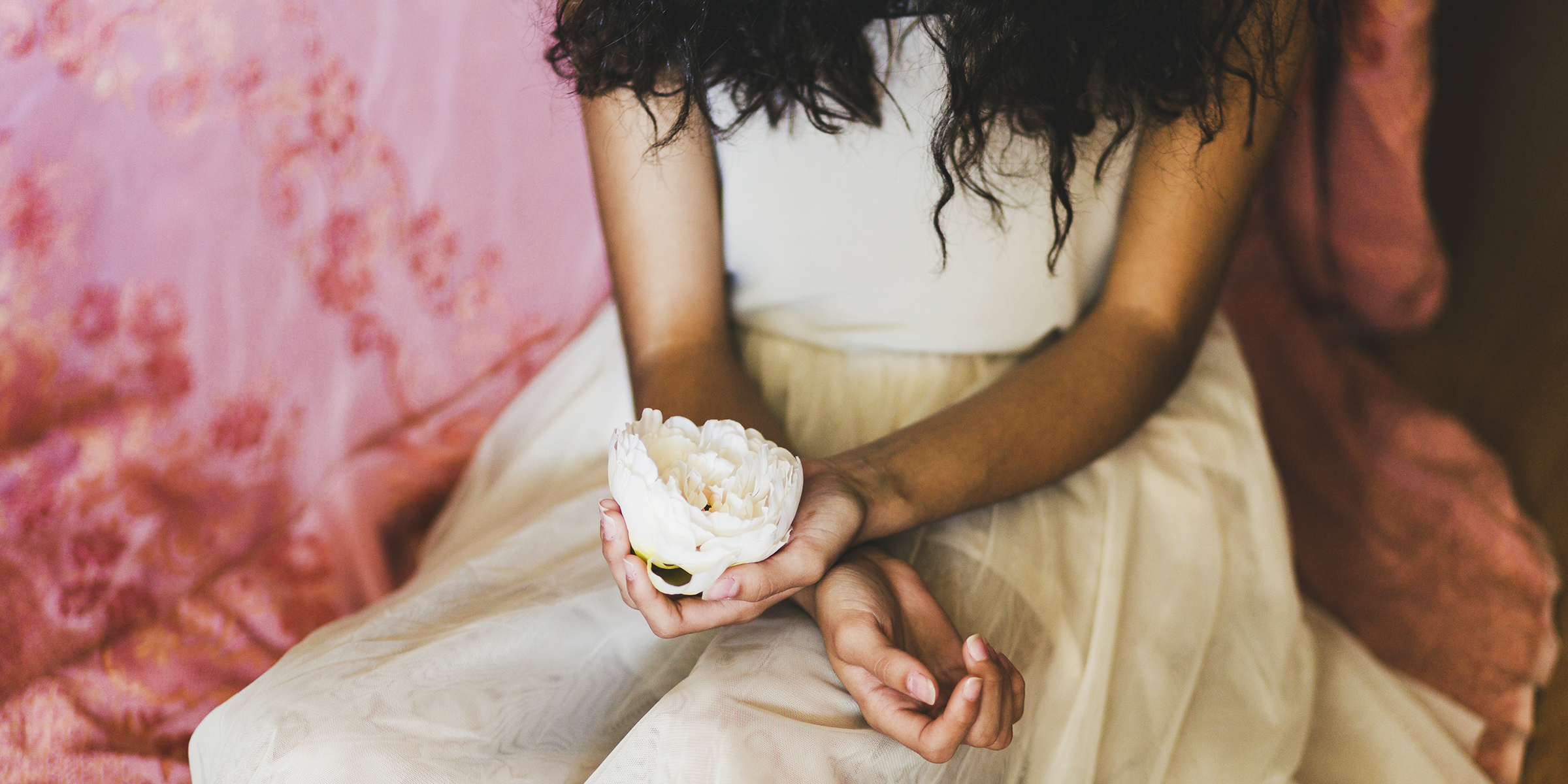 Foto recortada de una mujer sujetando una flor | Fuente: Freepik