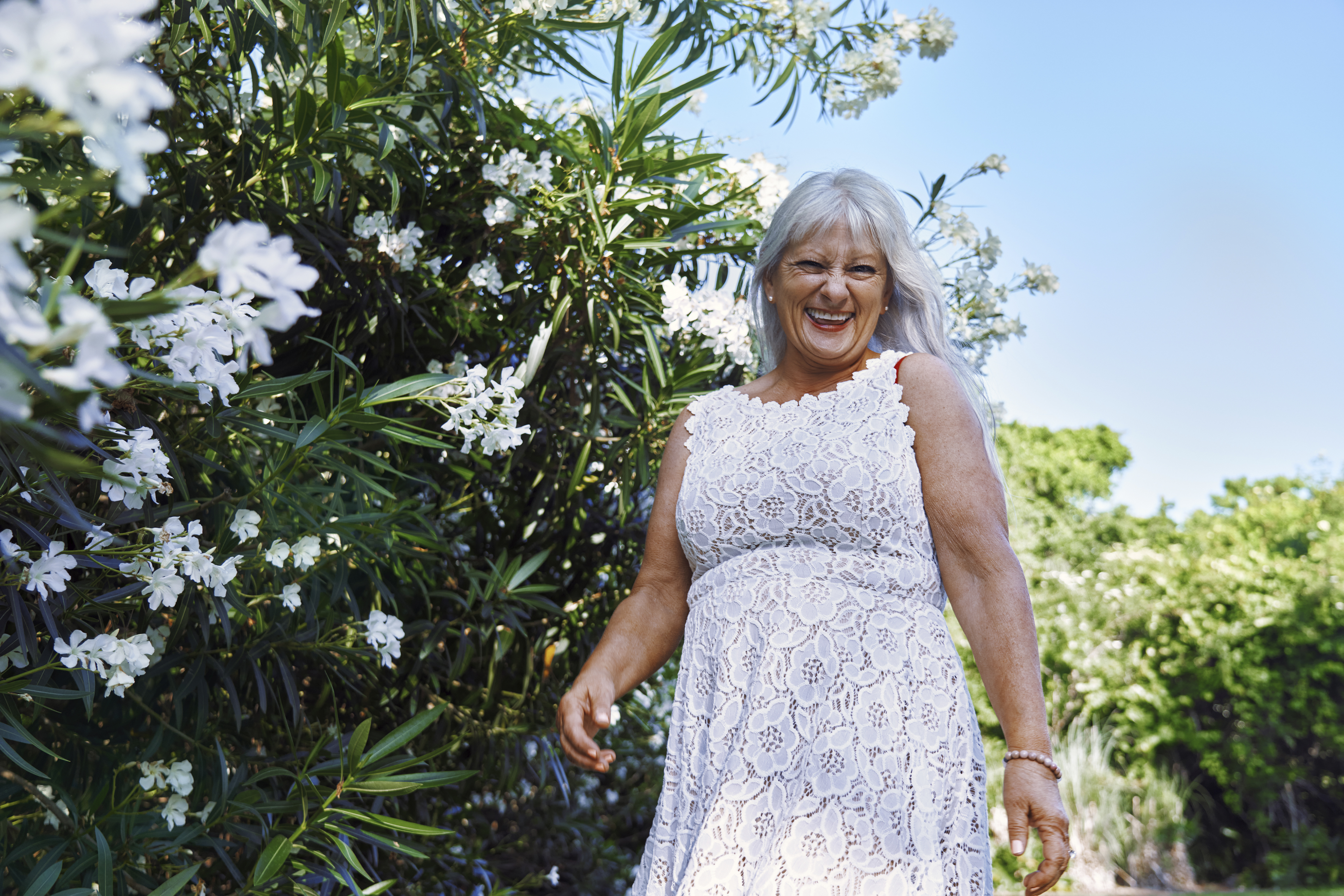 Mujer mayor feliz con un vestido blanco | Fuente: Getty Images