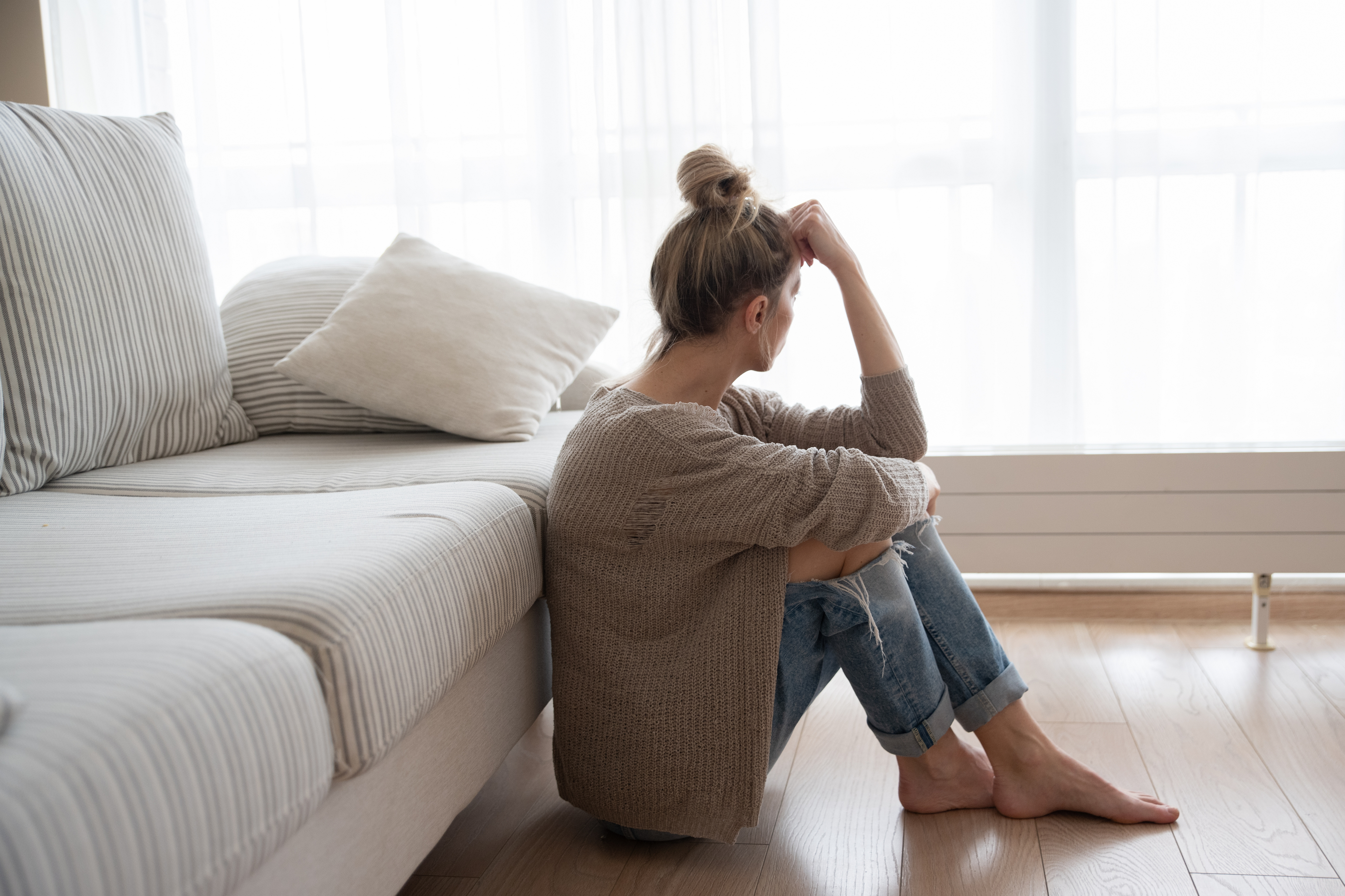 Una mujer deprimida sentada en el suelo | Fuente: Shutterstock