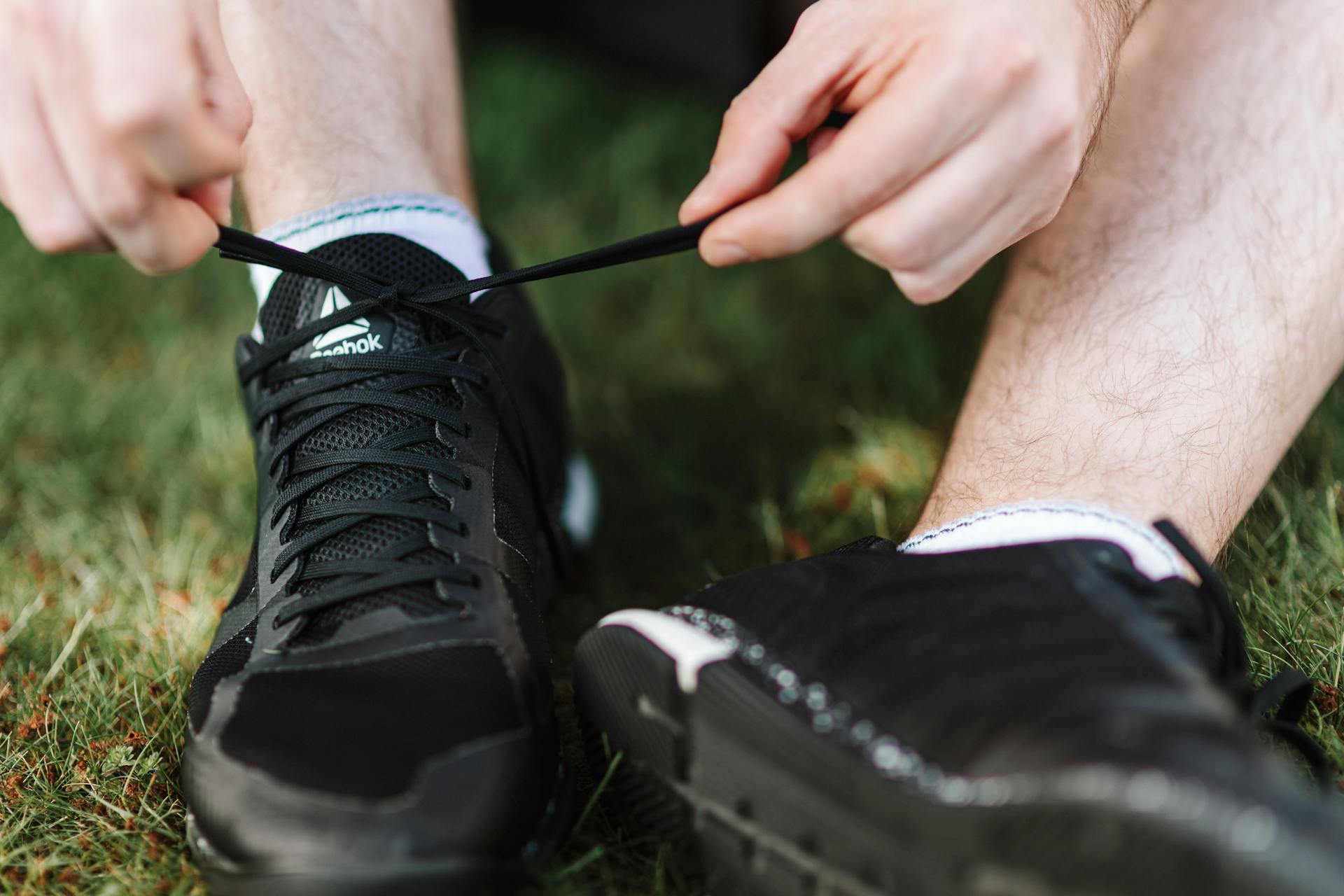 Un hombre atándose los cordones de los zapatos | Fuente: Pexels