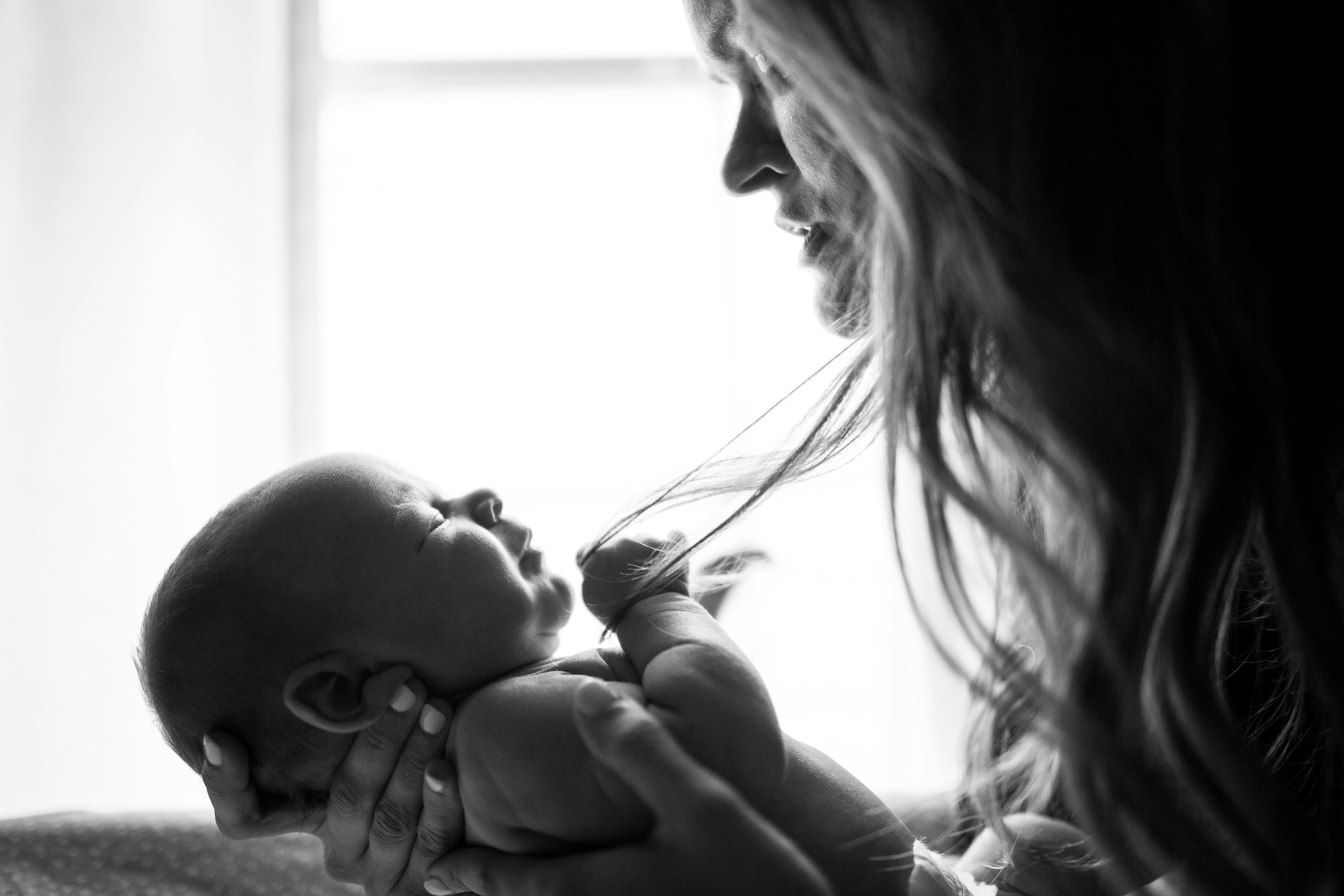 Una madre triste mirando a su bebé | Fuente: Unsplash