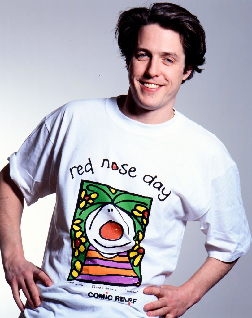 Hugh Grant modela la camiseta de la campaña para promover el Día de la Nariz Roja en 1995, Inglaterra. | Foto: Getty Images