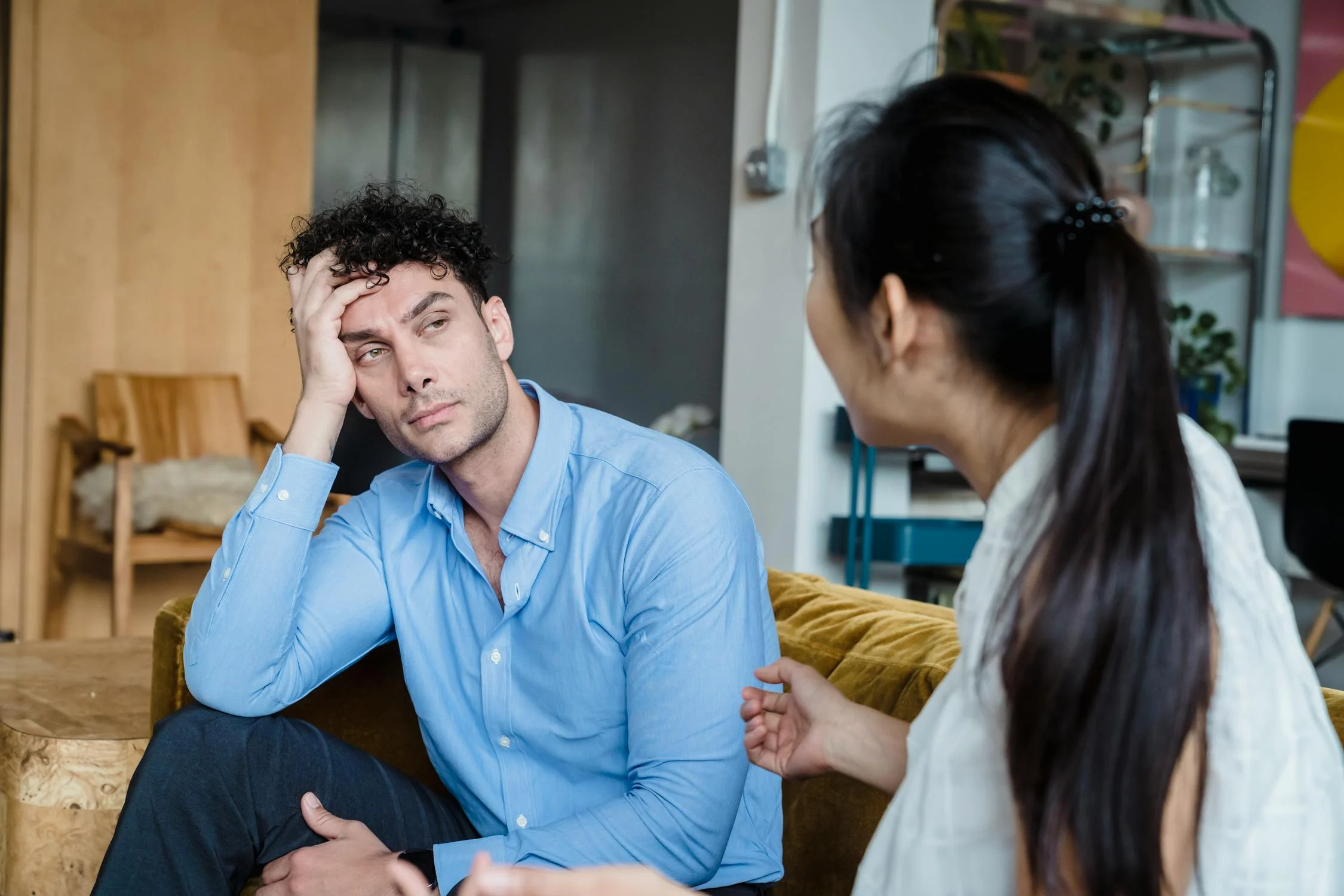 Una mujer hablando con un hombre en su salón | Fuente: Pexels