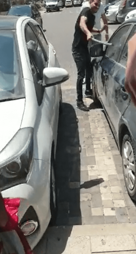Un hombre intenta romper una ventanilla del coche. | Foto: Reddit/u/hardisc