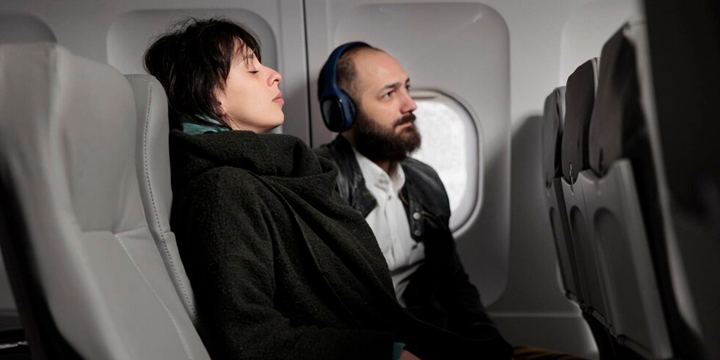 Un hombre y una mujer relajándose en un vuelo | Fuente: Freepik